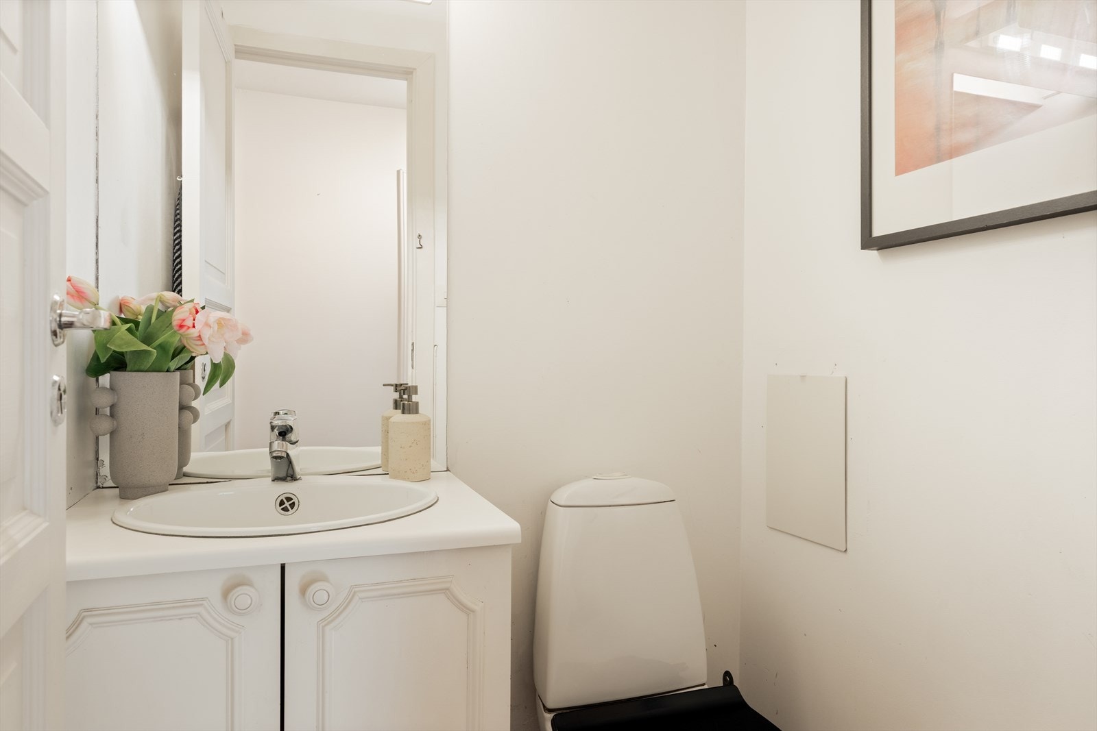 Separat toalettrom på ca. 1,3 m² med servant, speil og praktisk oppbevaringsplass i underskap. Galleribilde