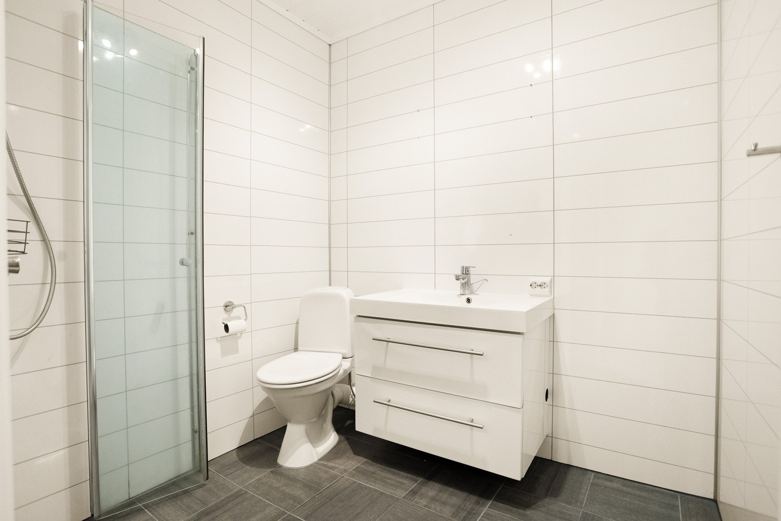 Badet har romslig utforming med flislagt gulv og elektriske varmekabler. Galleribilde