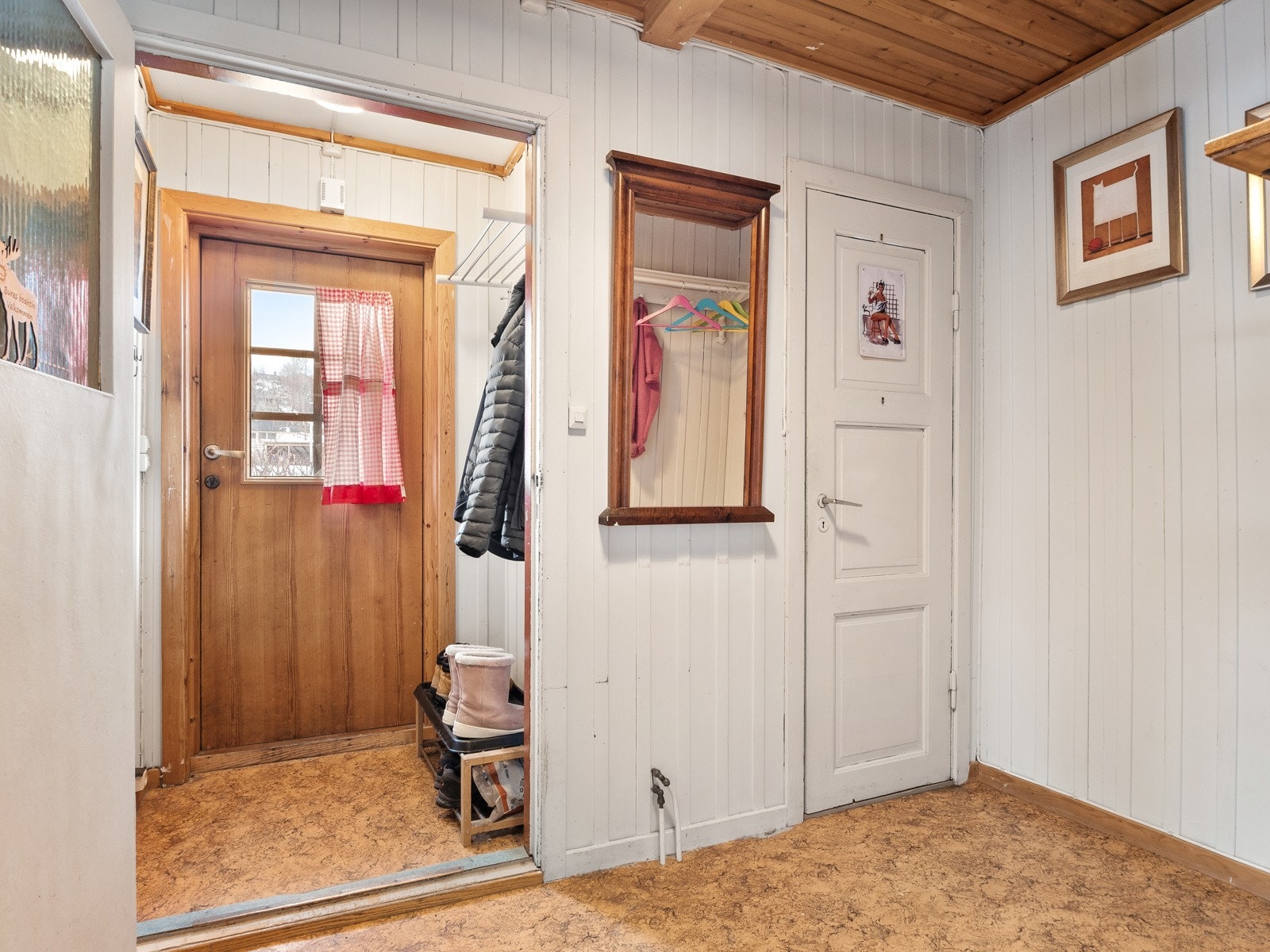 Man kommer inn i et vindfang med plass til oppbevaring, og derfra kommer man inn i en hall med mer oppbevaringsplass Galleribilde