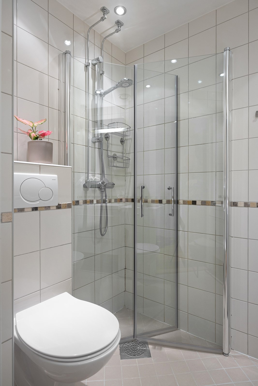 Badet er utstyrt med vegghengt wc, servant med skuffer under og dusj i hjørne med innadslående dører. Det er opplegg for vaskemaskin. Galleribilde