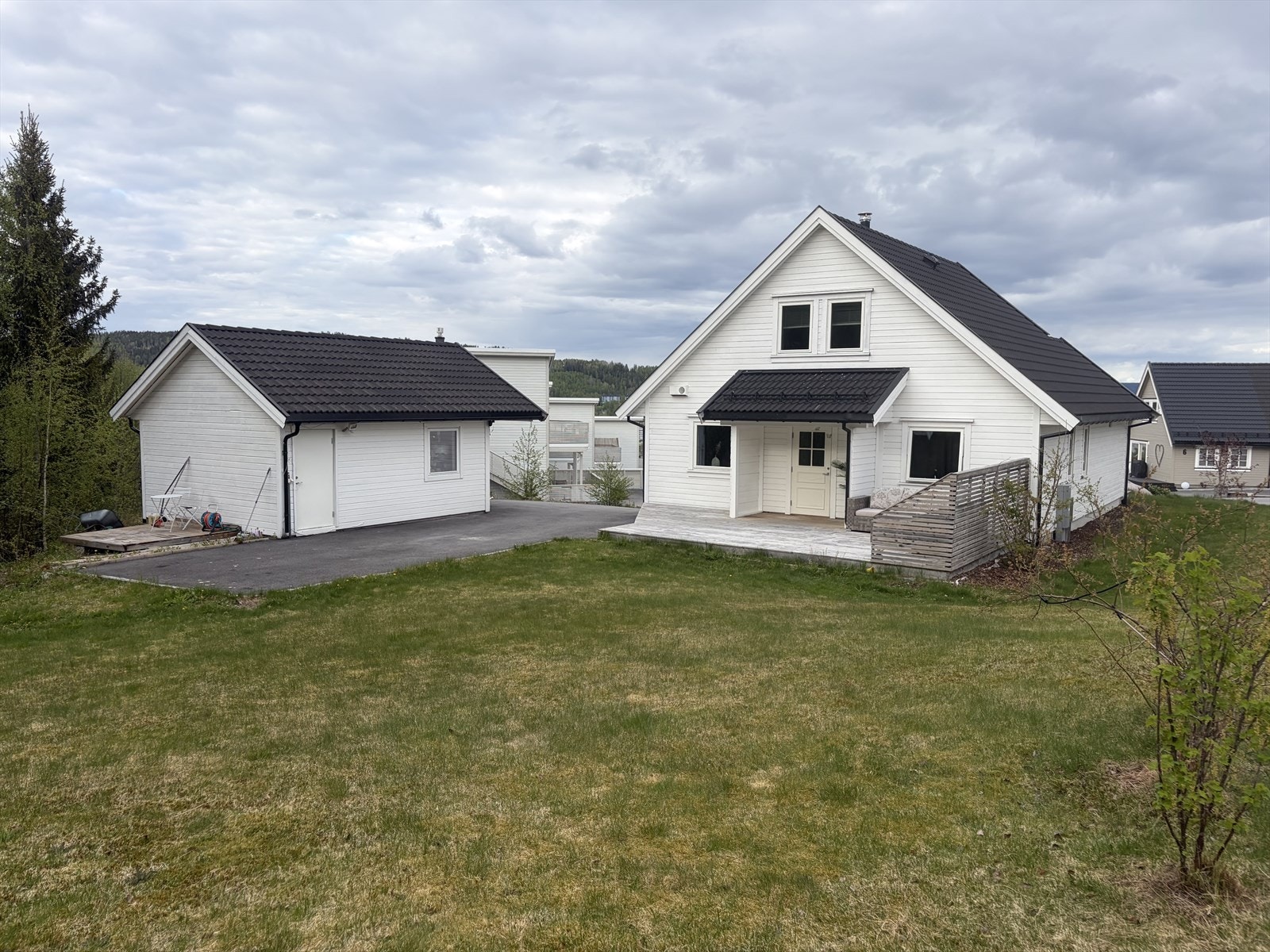 Tilnærmet flat hage på baksiden, som grenser mot skogen. Galleribilde