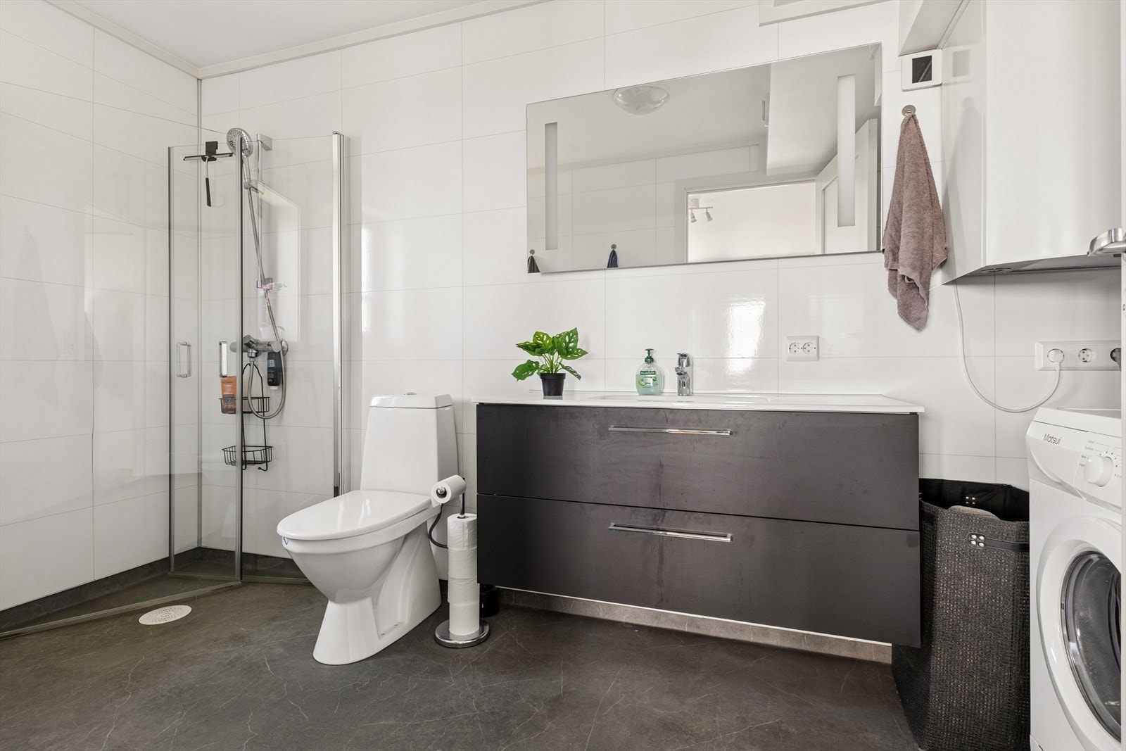 Leiligheten har et praktisk og funksjonelt baderom med gulvbelegg og dusjhjørne. Badet er også tilrettelagt med opplegg for vaskemaskin. Galleribilde