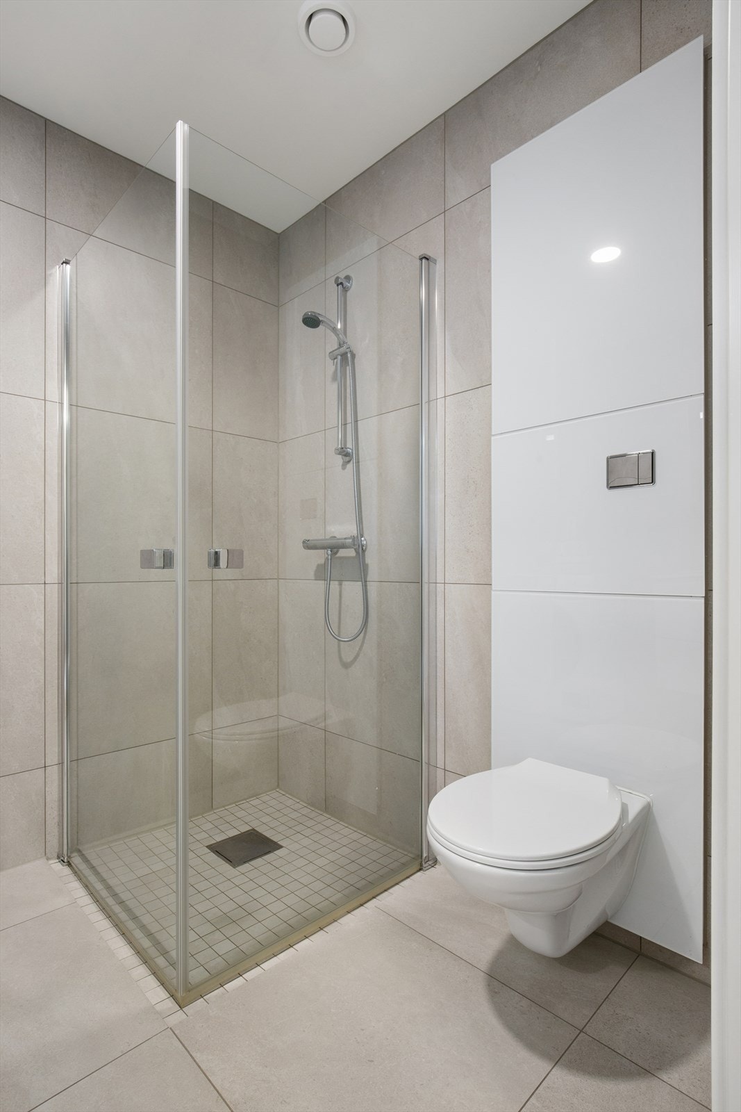 Badet er ellers utstyrt med dusjhjørne, vegghengt toalett og baderomsinnredning med nedfelt servant. I tillegg har man opplegg for vaskemaskin og avtrekk via balansert ventilasjonsanlegg. Galleribilde