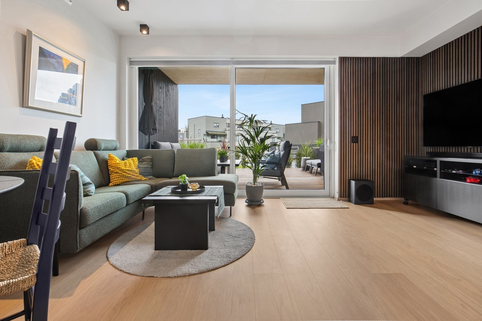Rommet har plass til sofagruppe og spisebord side om side, og overgangen mellom inne og ute er sømløs når dørene skyves til side. Galleribilde