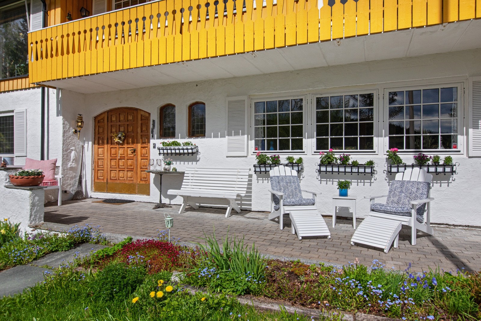 Uteplass ved inngangspartiet med steinlagt dekke. Delvis overbygget av verandaen. Galleribilde