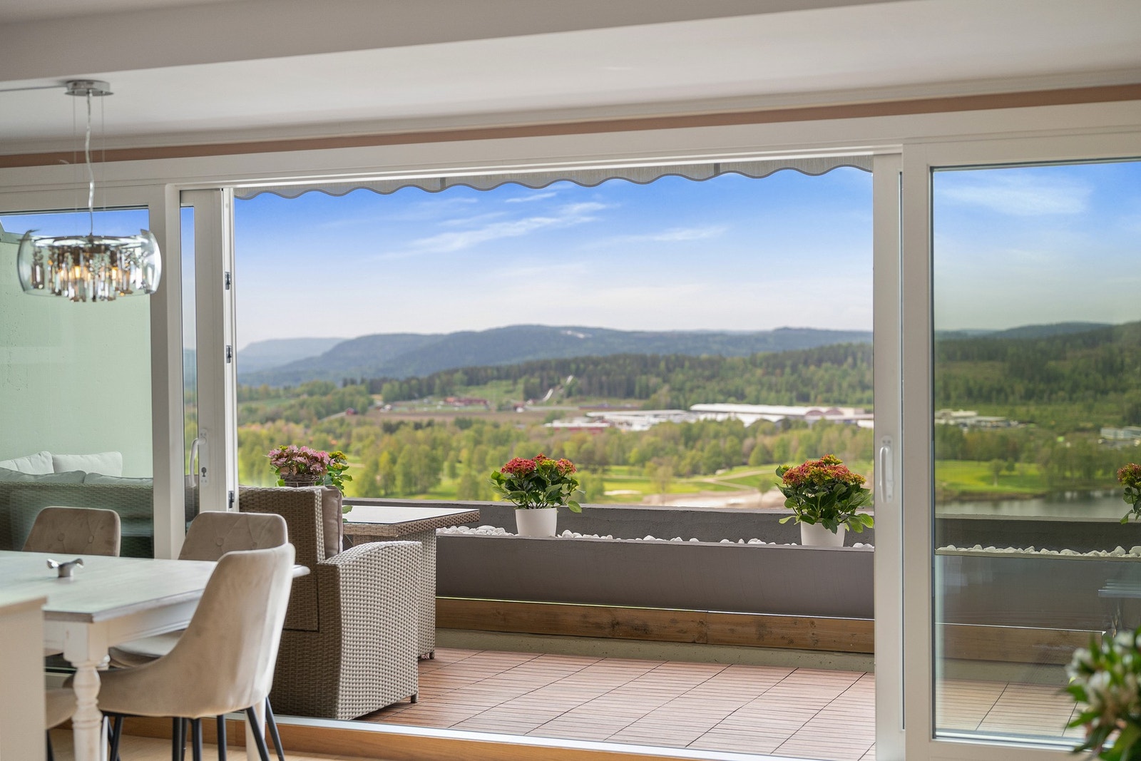 Den åpne planløsningen og utsikten mot vann og grønne omgivelser gir boligen en luftig og eksklusiv atmosfære Galleribilde