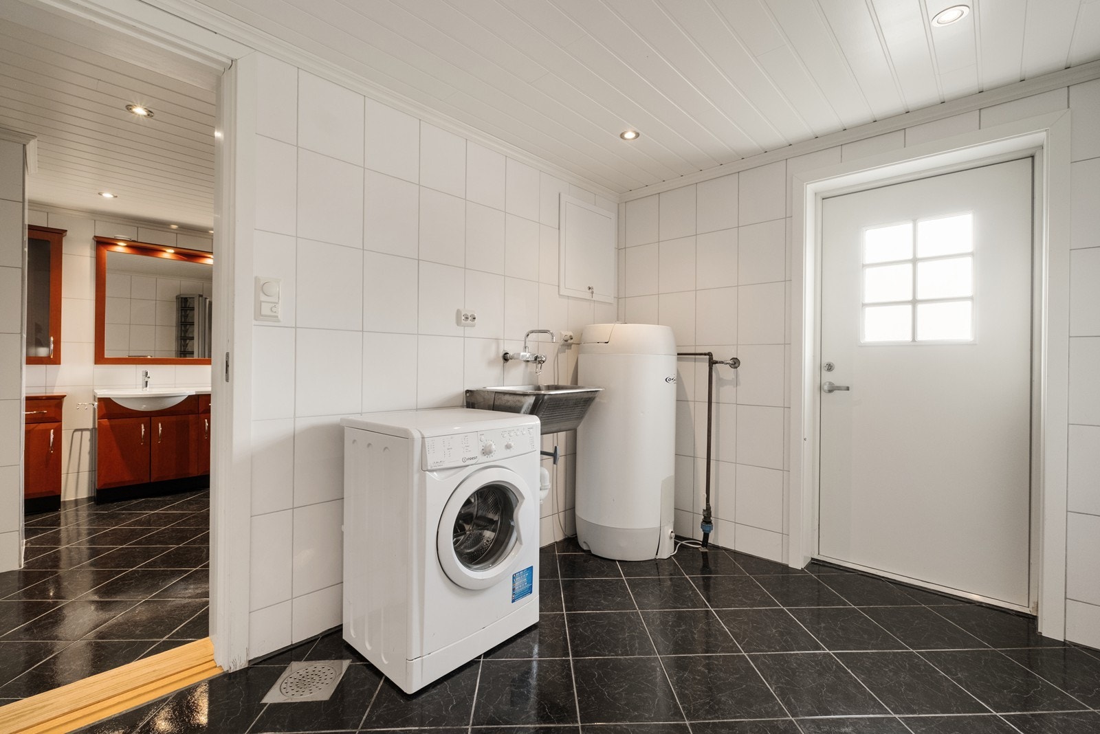 Innenfor badet finner man et flislagt vaskerom med utgang til uteområdet. Galleribilde