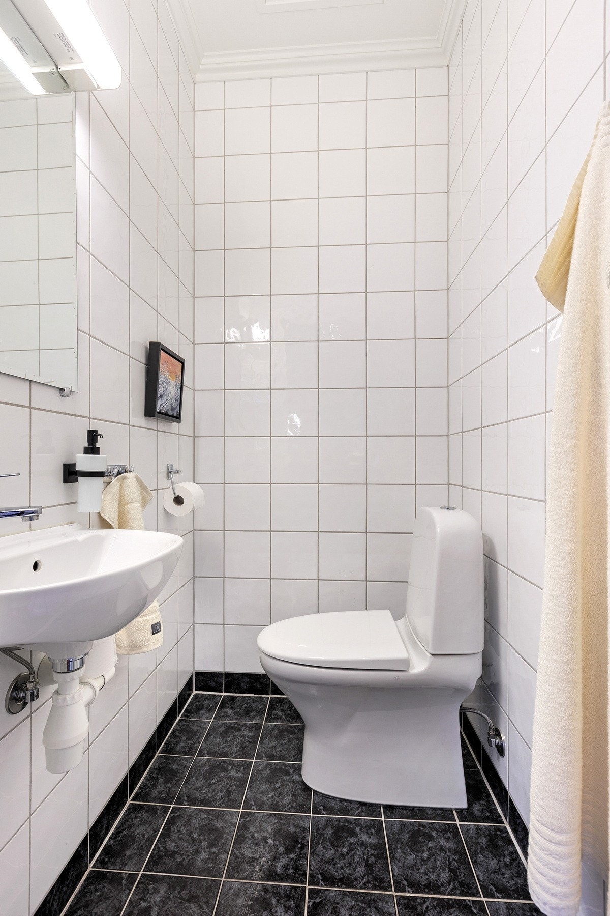 Romslig toalettrom med lyse flater og funksjonell planløsning som gir et rent og tidløst uttrykk. Galleribilde