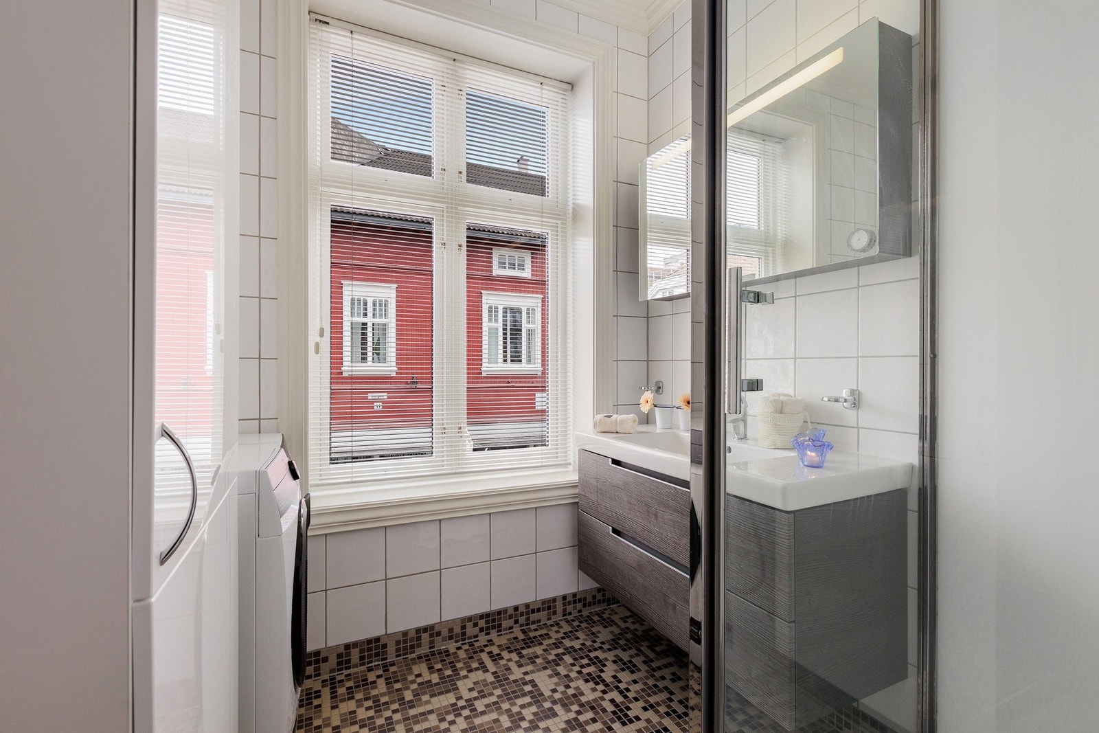 Store vinduer slipper inn naturlig lys og bidrar til en lys og luftig atmosfære på badet. Galleribilde