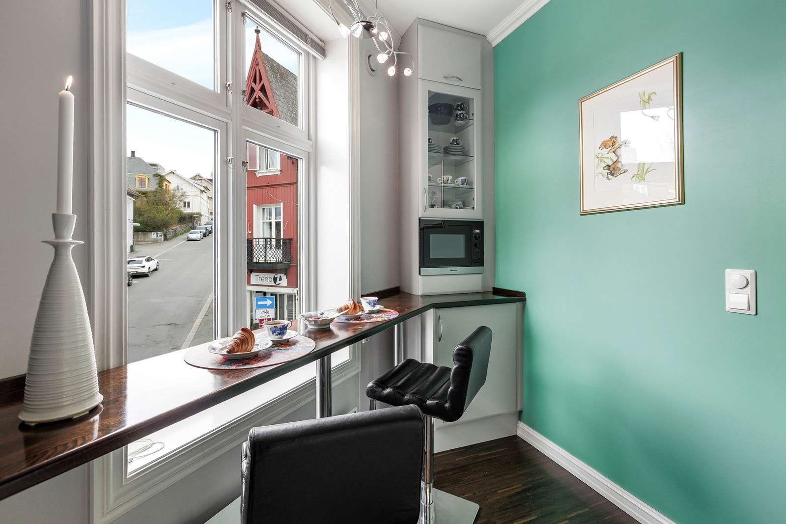 Praktisk kjøkkenløsning med plassbygget sitteplass og moderne uttrykk. Galleribilde