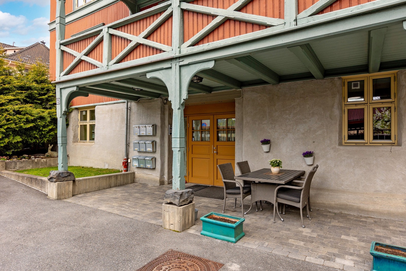 Felles inngangsparti til leilighetene i bygget. Overbygget med sittegruppe som disponeres av sameiets beboere. Galleribilde