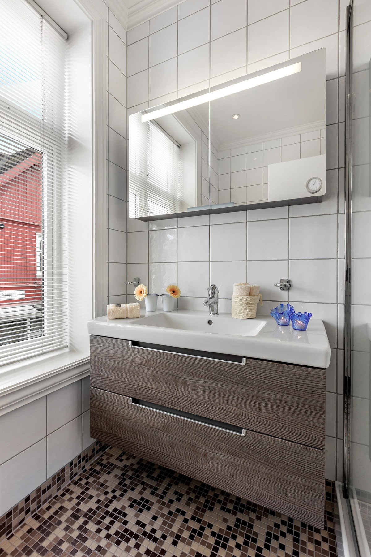 Servant med god oppbevaringsplass og store speilflater som gir badet et lyst og moderne uttrykk. Galleribilde