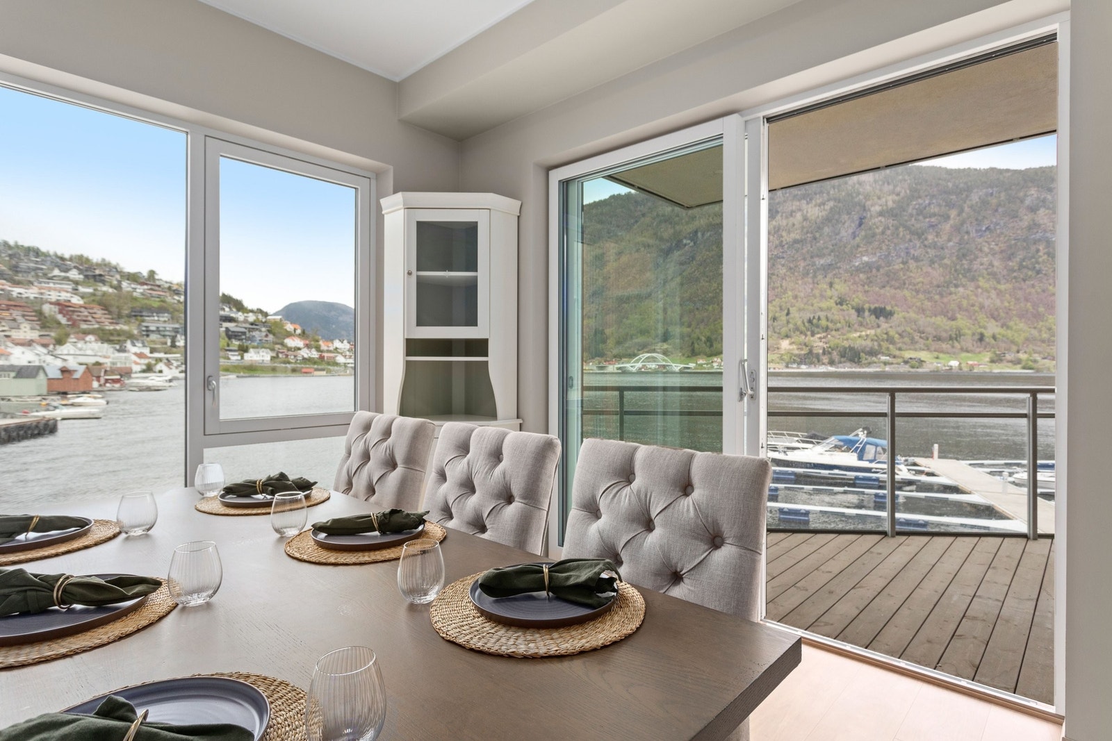 Soverom med fleksibel bruk – her innredet som spisestue. Rommet har god plass til dobbeltseng og tilbyr fantastisk utsikt over Sogndalsfjorden gjennom store vinduer og direkte utgang til balkongen. Galleribilde