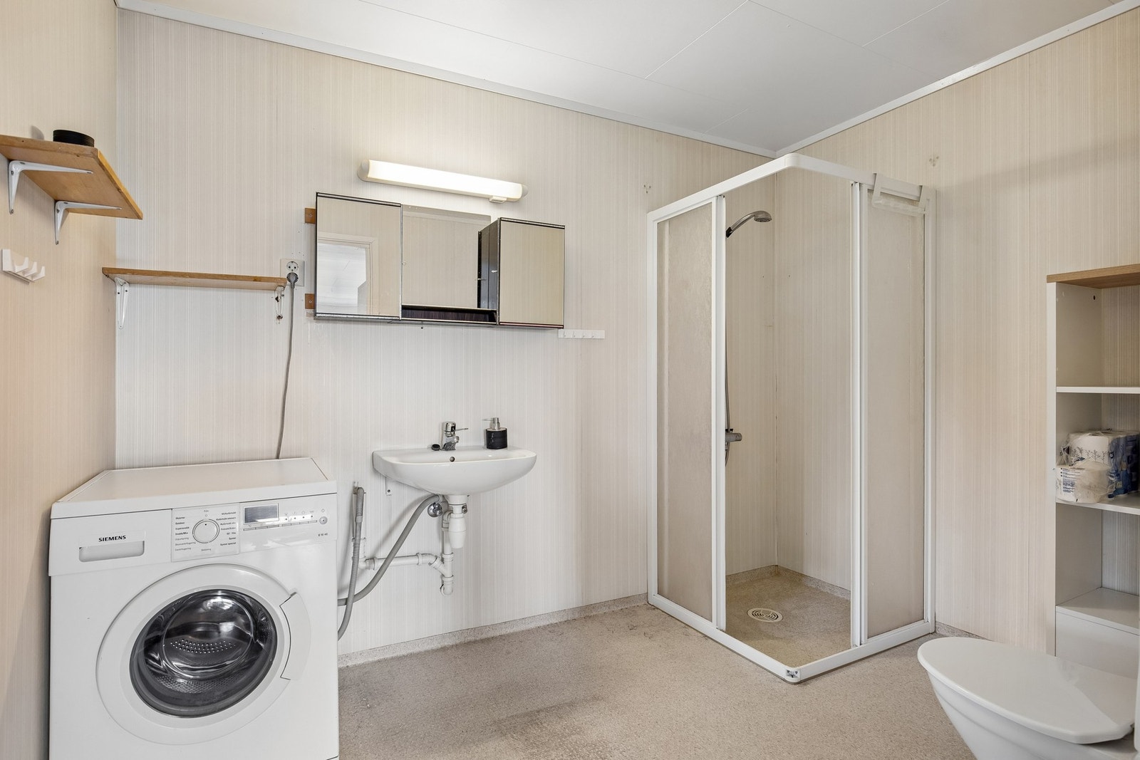 Badet har opplegg for vaskemaskin, dusjhjørne, servant og toalett. Galleribilde