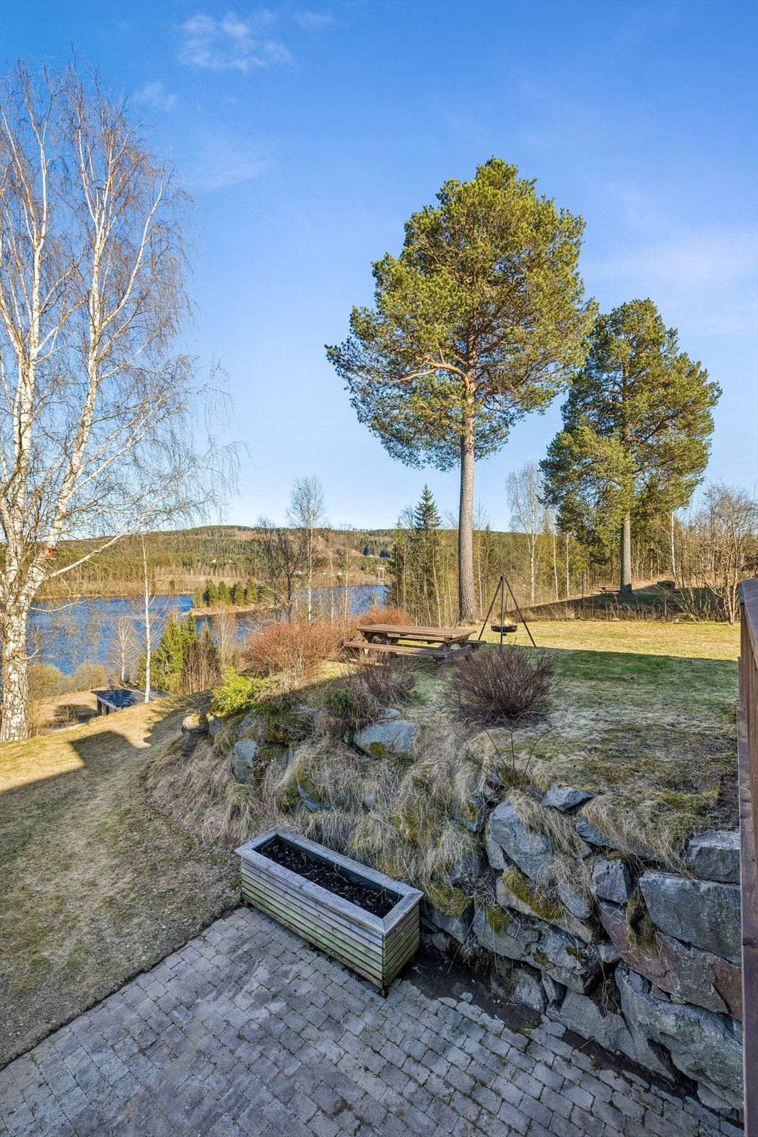 Tomten er opparbeidet med plenarealer og en forstøtningsmur i naturstein. Galleribilde