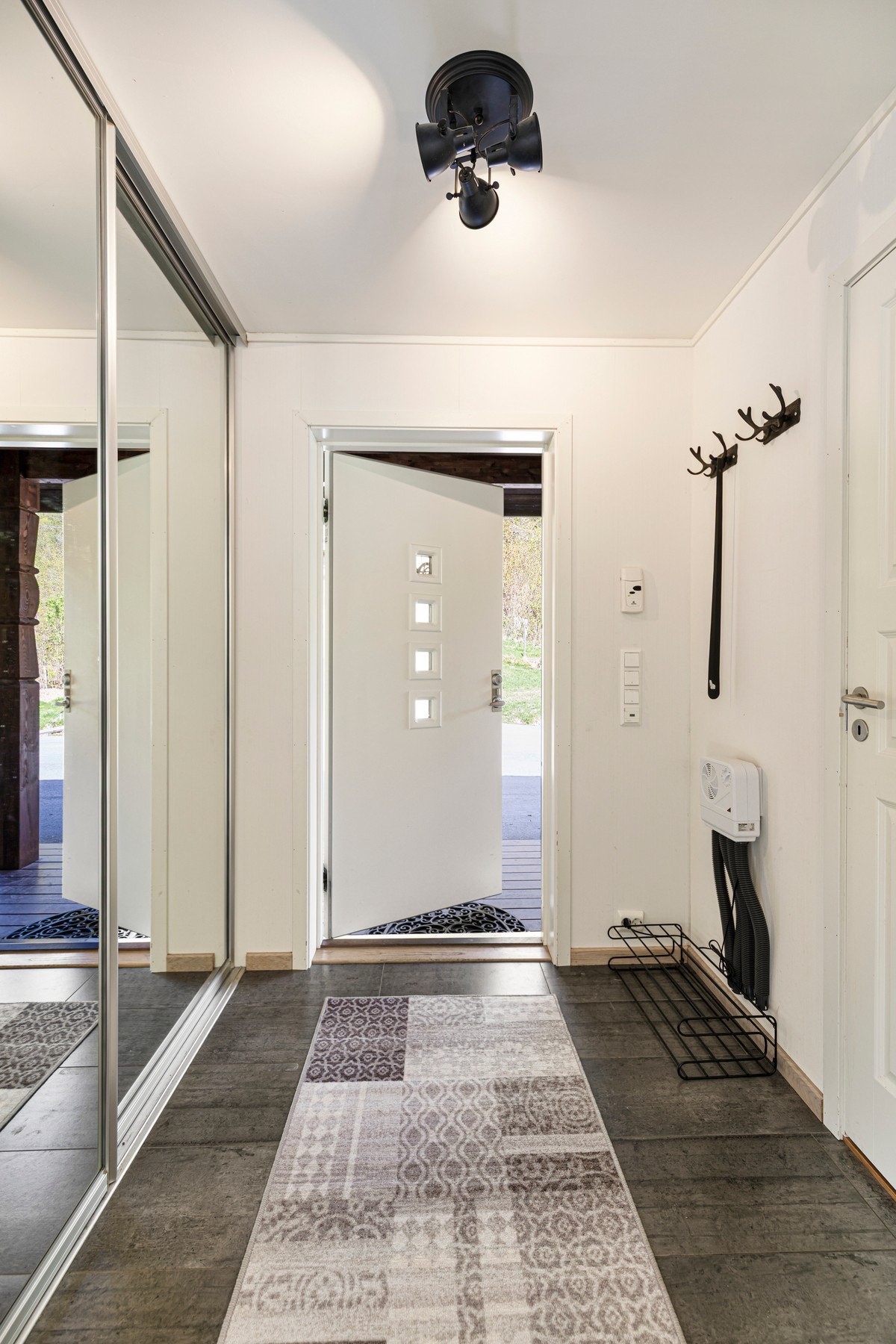 Flislagt entre med varmekabler i gulv og skyvedørsgarderobe med speilfronter. Galleribilde