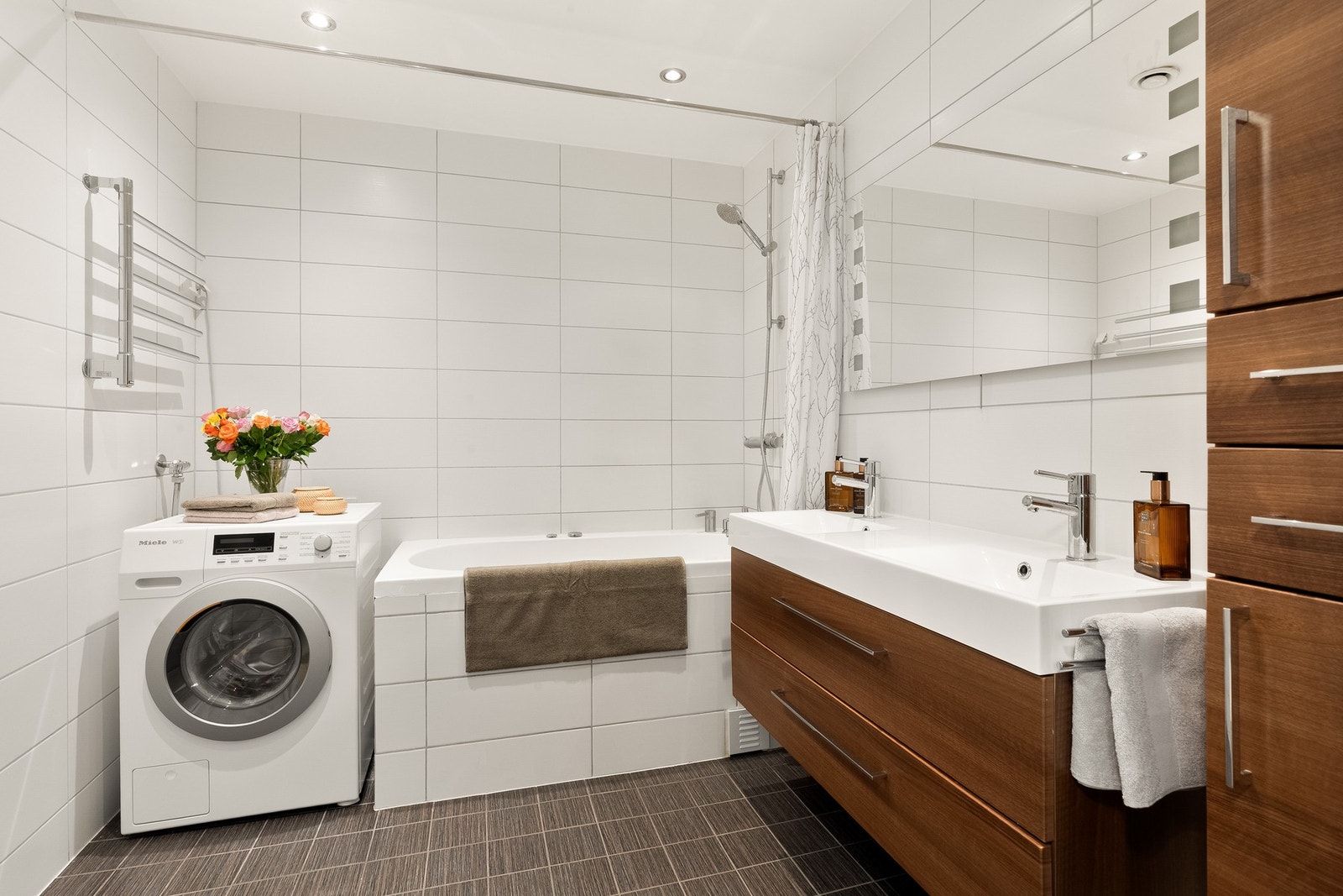 Badet ble rehabilitert i 2008 og fremstår tidløst med flislagte overflater og god plass Galleribilde