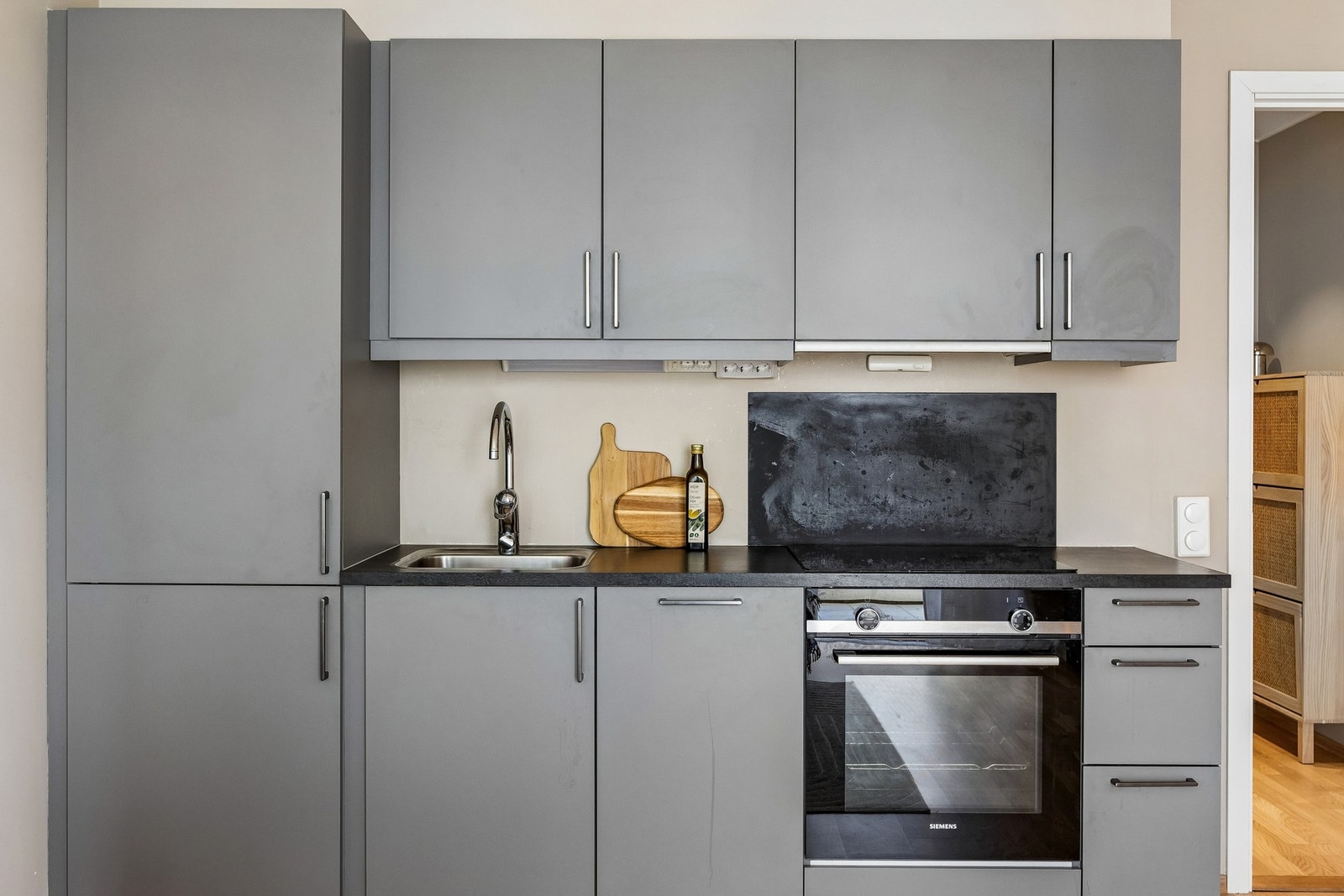 Kjøkkenet har en moderne og stilren innredning med glatte fronter og laminert benkeplate. Det er integrerte hvitevarer, herunder stekeovn, platetopp, oppvaskmaskin samt kjøleskap med fryser. Galleribilde