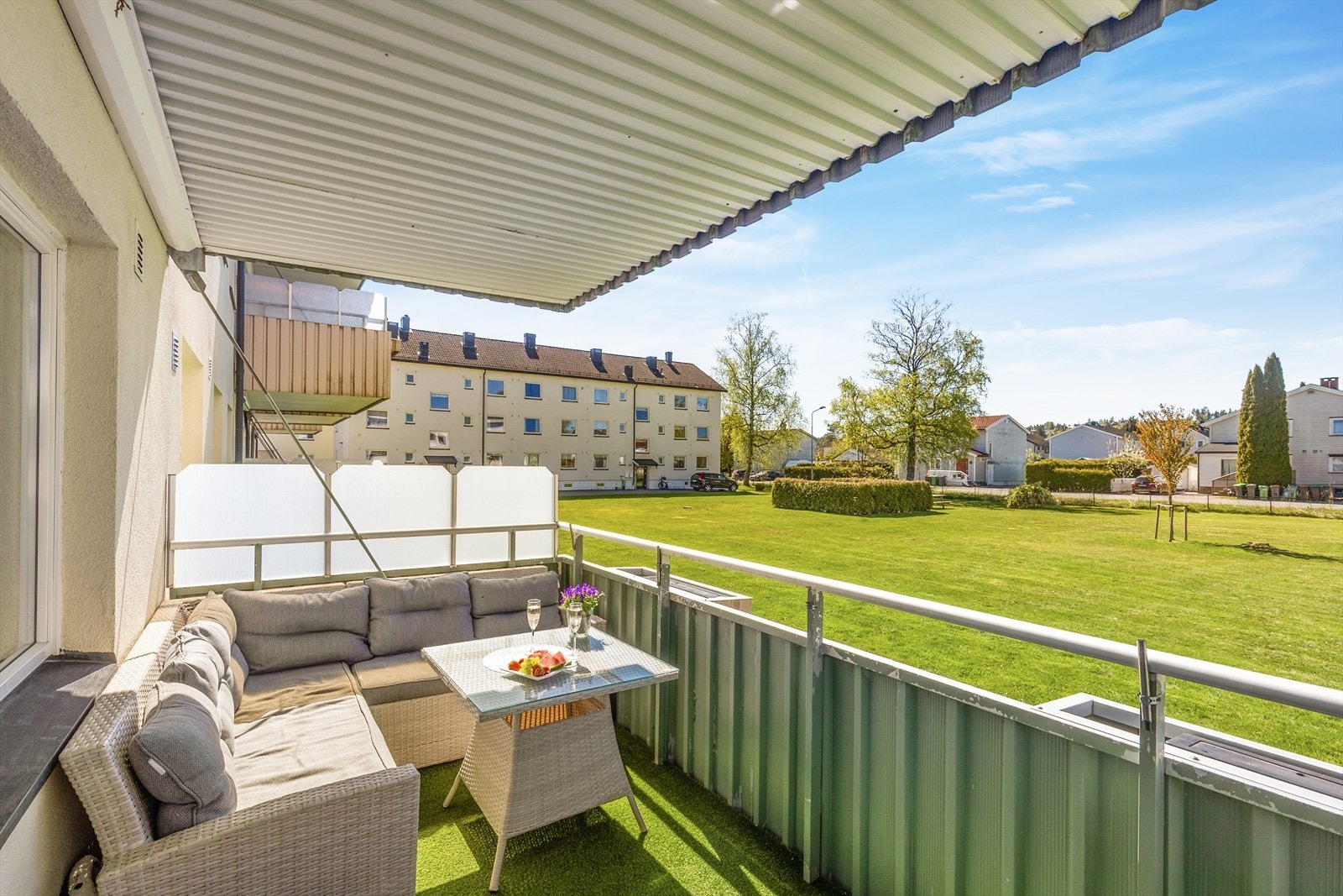 Fra stuen er det utgang til en romslig og overbygget balkong, med gode solforhold og hyggelig utsikt over nærområdet! Her er det fin plass til utemøbler, samt er det montert vindskjerming på sidene. Galleribilde