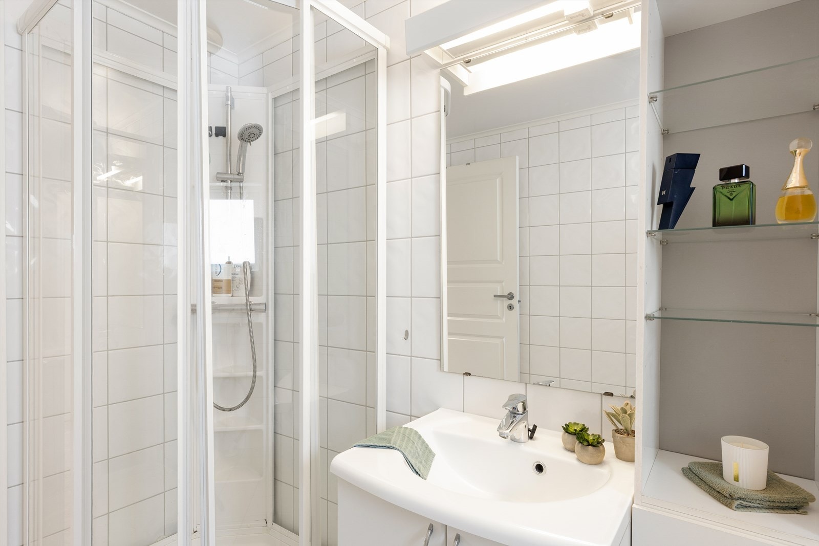 Servantinnredning med skap og heldekkende servant, samt speil. Badet har elektrisk vifte i yttervegg med tilluft ved flat terskel. Galleribilde