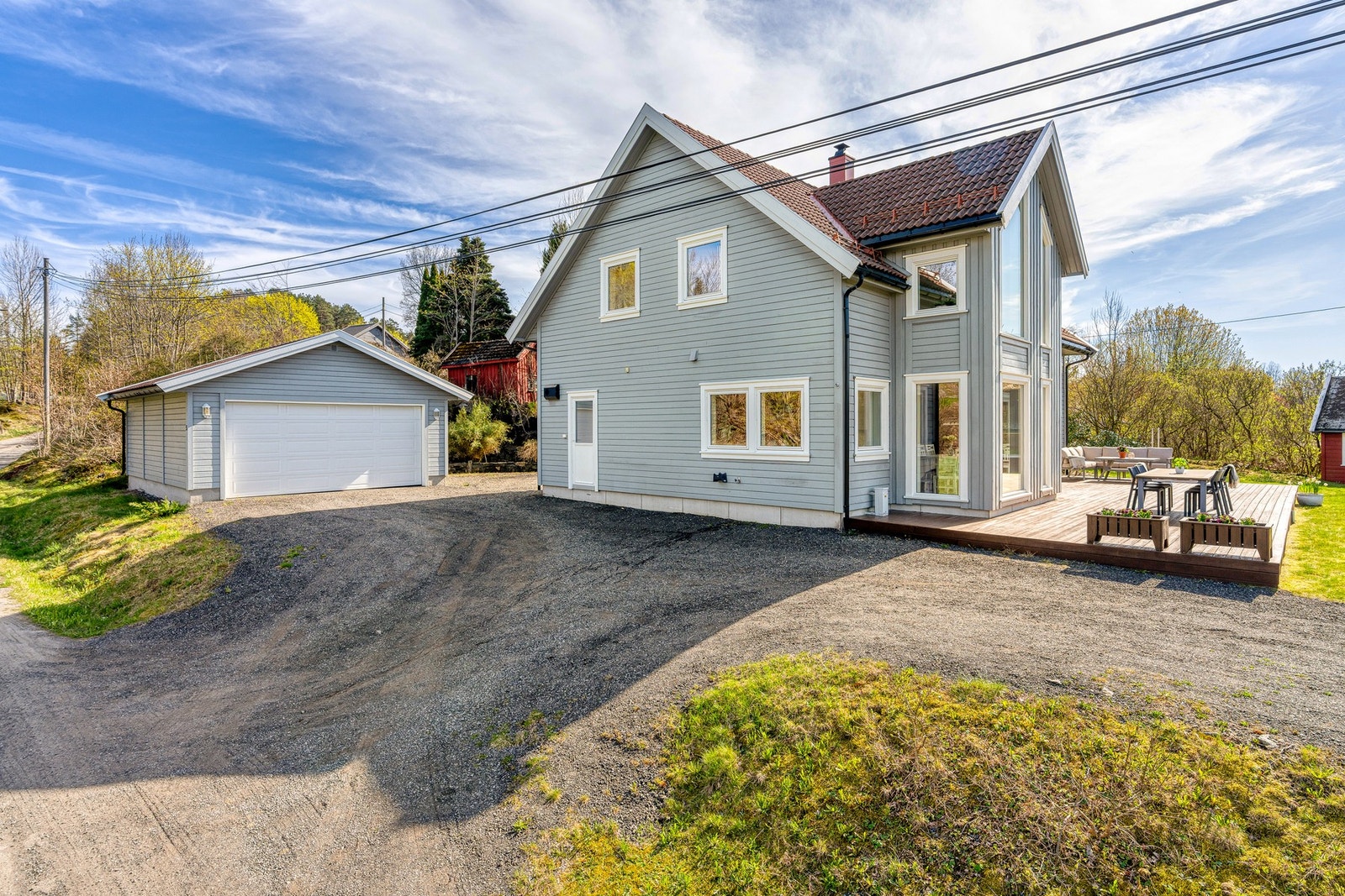Innbydende eiendom med romslig gårdsplass, frittstående garasje og flotte uteområder. Galleribilde