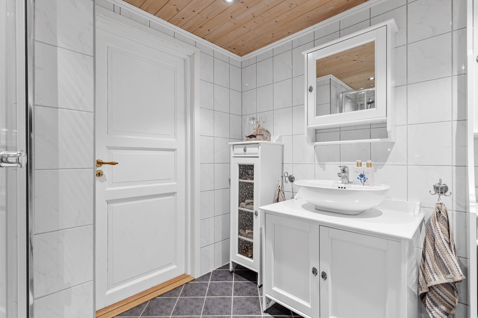 Badet har toalett, servant med innredning og speil, samt dusjkabinett i hjørnet. (Ikke godkjent for varig opphold) Galleribilde