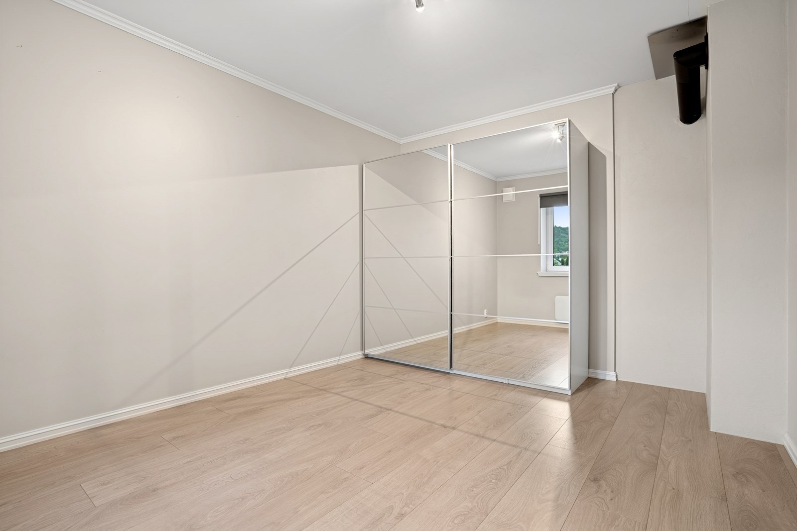 Lyst og innbydende rom med speilskyvedørsgarderobe og god plass til dobbeltseng, med moderne detaljer Galleribilde