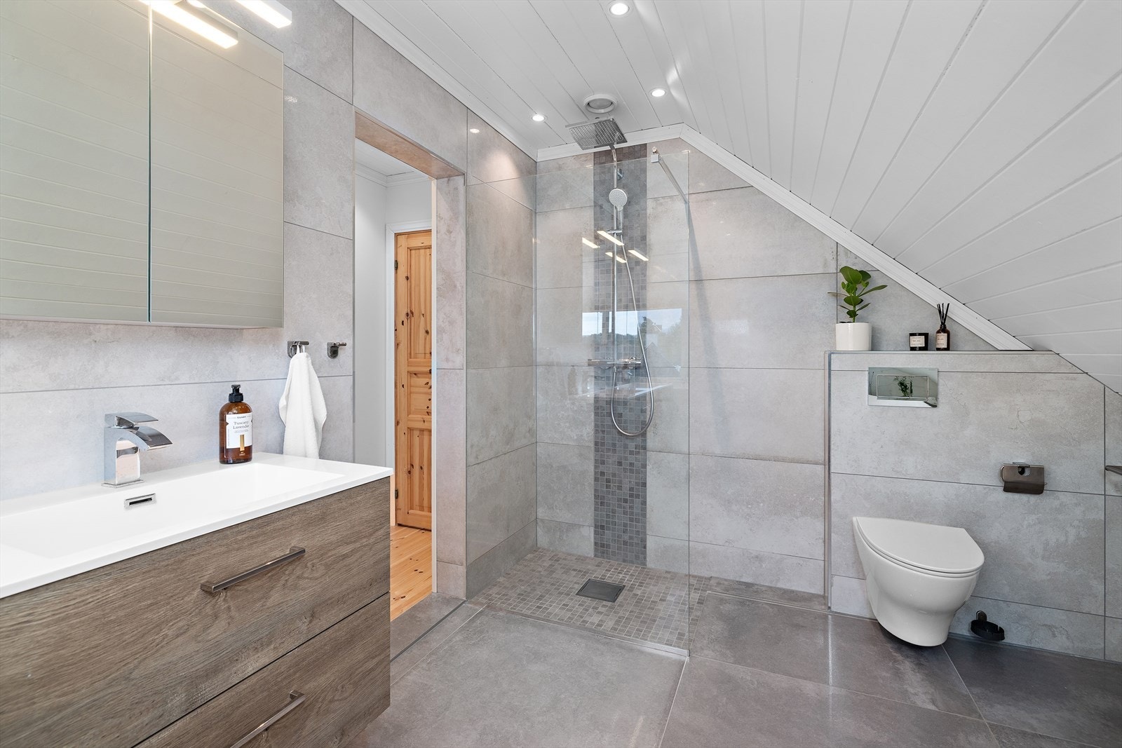 Badet har også en nedsenket dusjnisje med fastkarm i glass og vegghengt toalett. Galleribilde