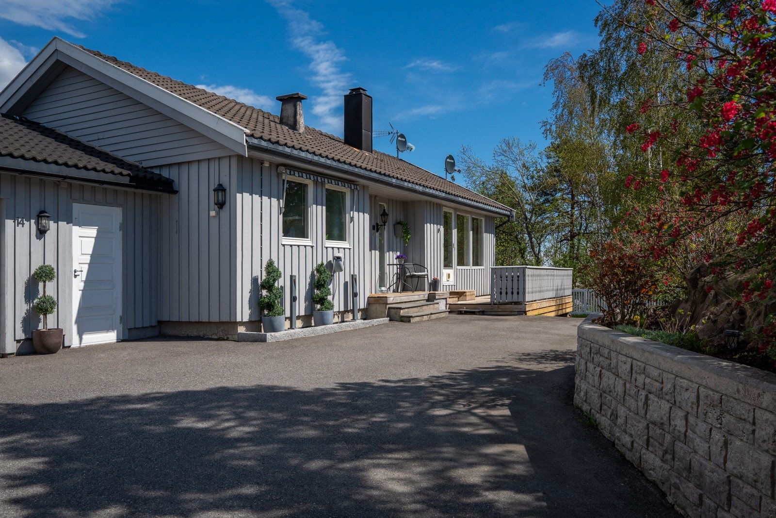 Asfaltert gårdstun med adkomst til øvre etasje, samt pent opparbeidede uteområder foran boligen. Galleribilde