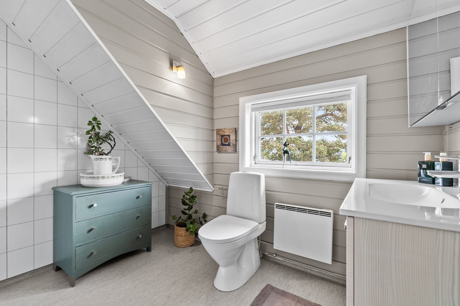 Badet er innredet med dusjhjørne, toalett og servant i pen innredning. Galleribilde