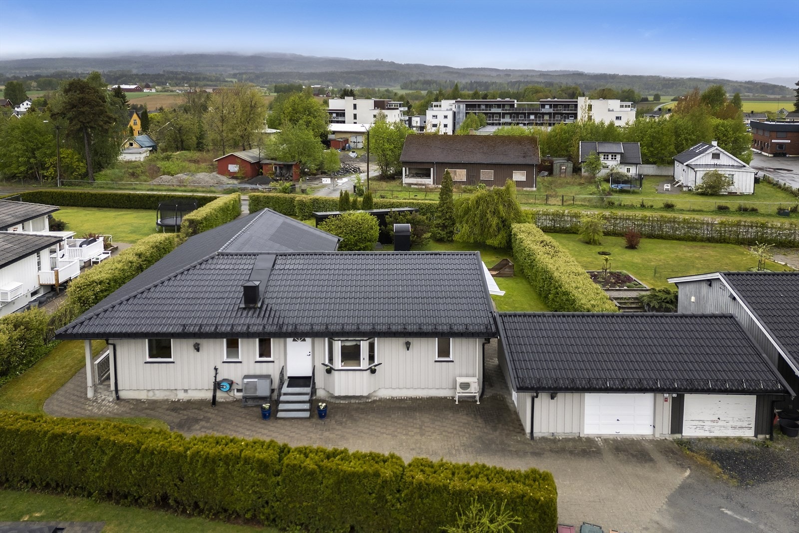 Eiendommen har en andel i en dobbeltgarasje og en gårdsplass med belegningsstein og flere biloppstillingsplasser. Galleribilde