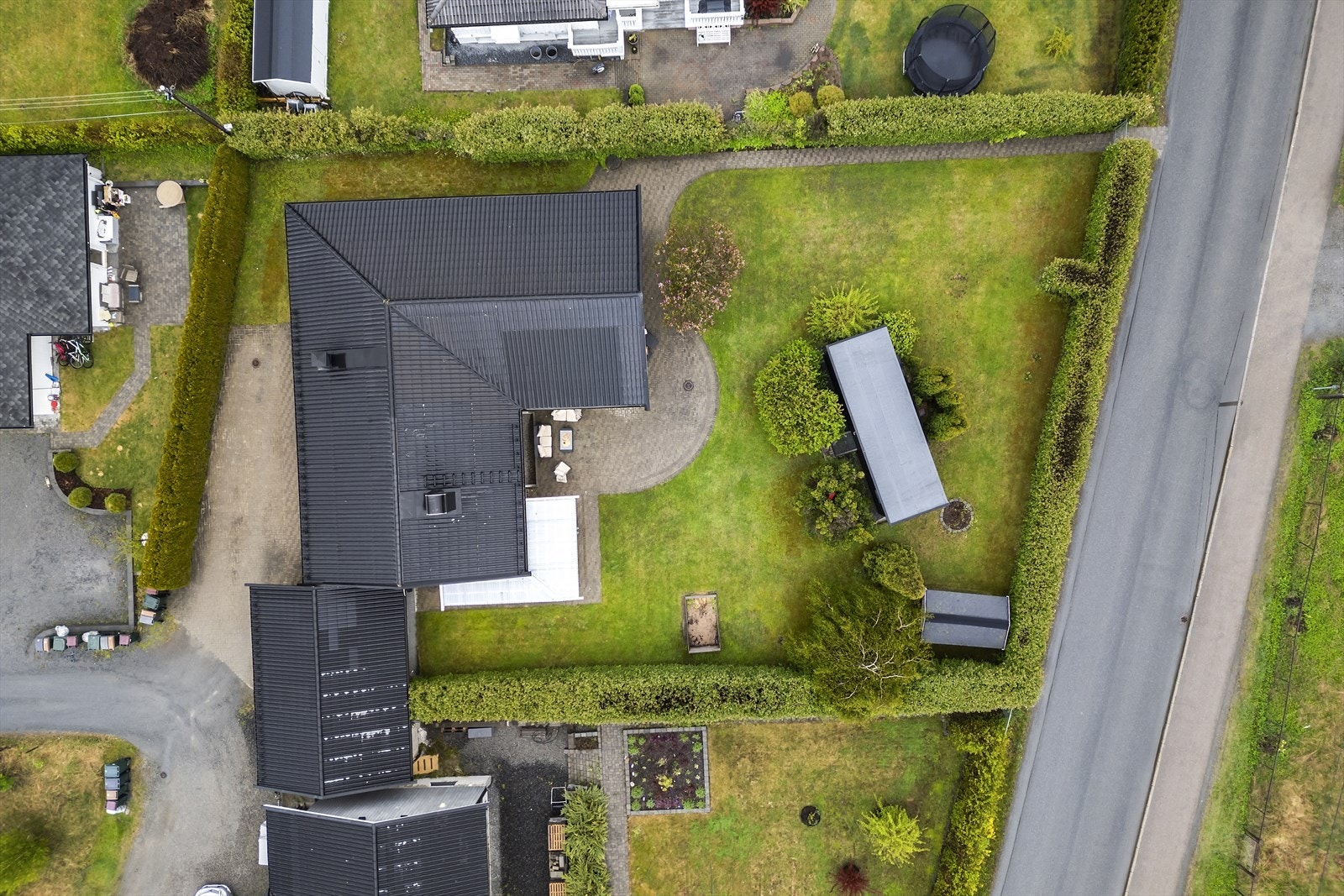 Tomten er flat og omkranset av hekk. I hagen står en frittstående bod på 17 m², oppført i 2023. Galleribilde