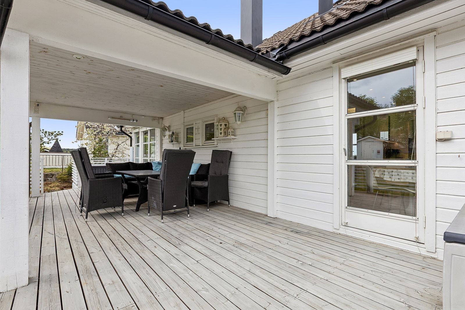 Stor terrasse med plass til sittegruppe og grill, og med utgang både fra stue og kjøkken. Galleribilde