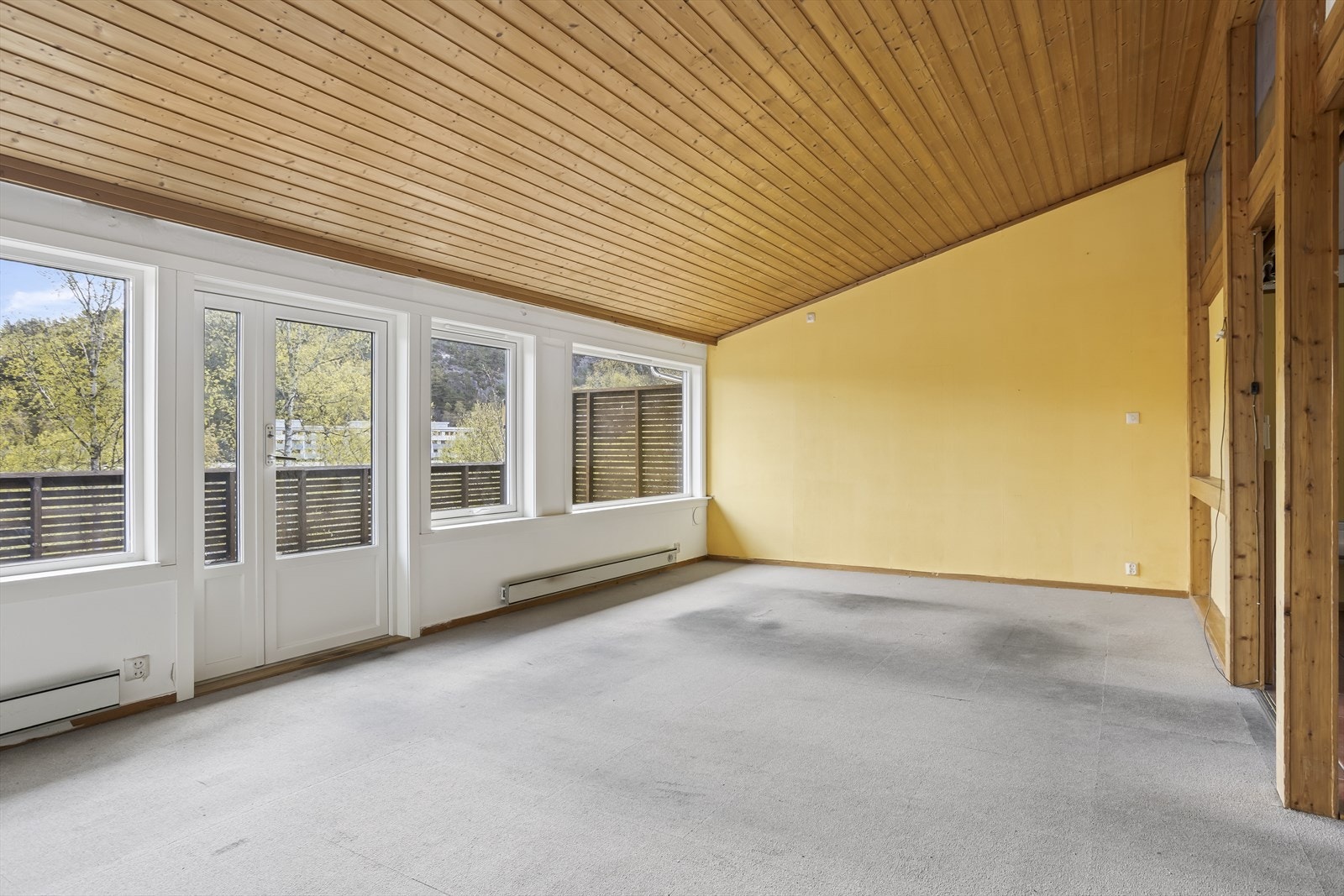 Stuen er boligens største rom og har en bred vindusrekke med terrassedør langs bakveggen. Galleribilde