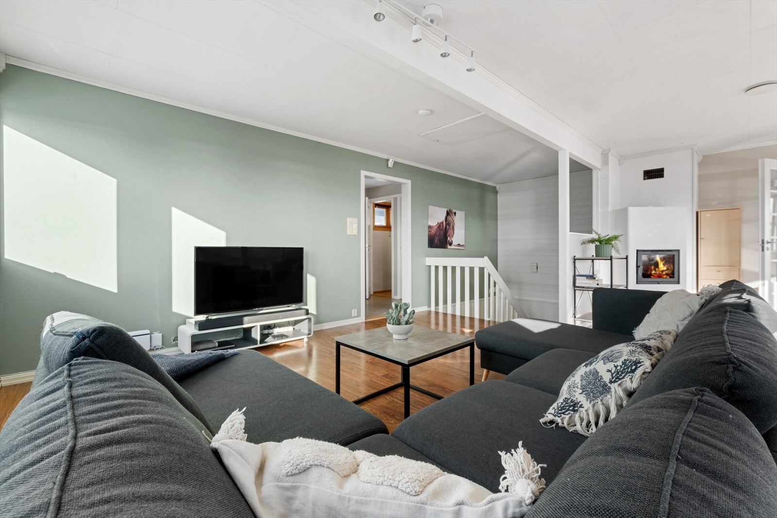 Stuen er lys og luftig med hygge fra en peis med stort flammebilde. Galleribilde