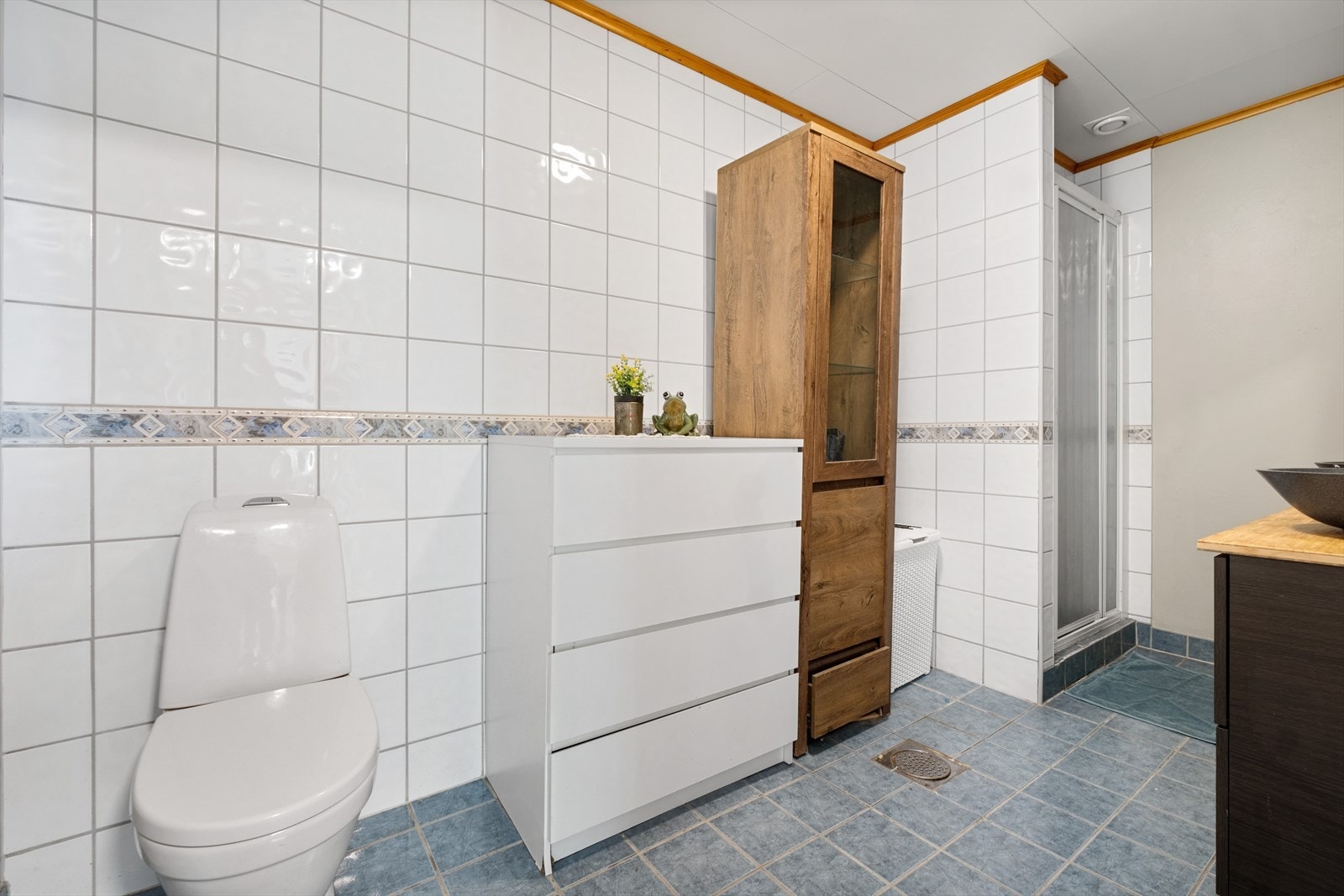 Badet har flislagt gulv med varmekabler og delvis flissatte veggflater. Galleribilde