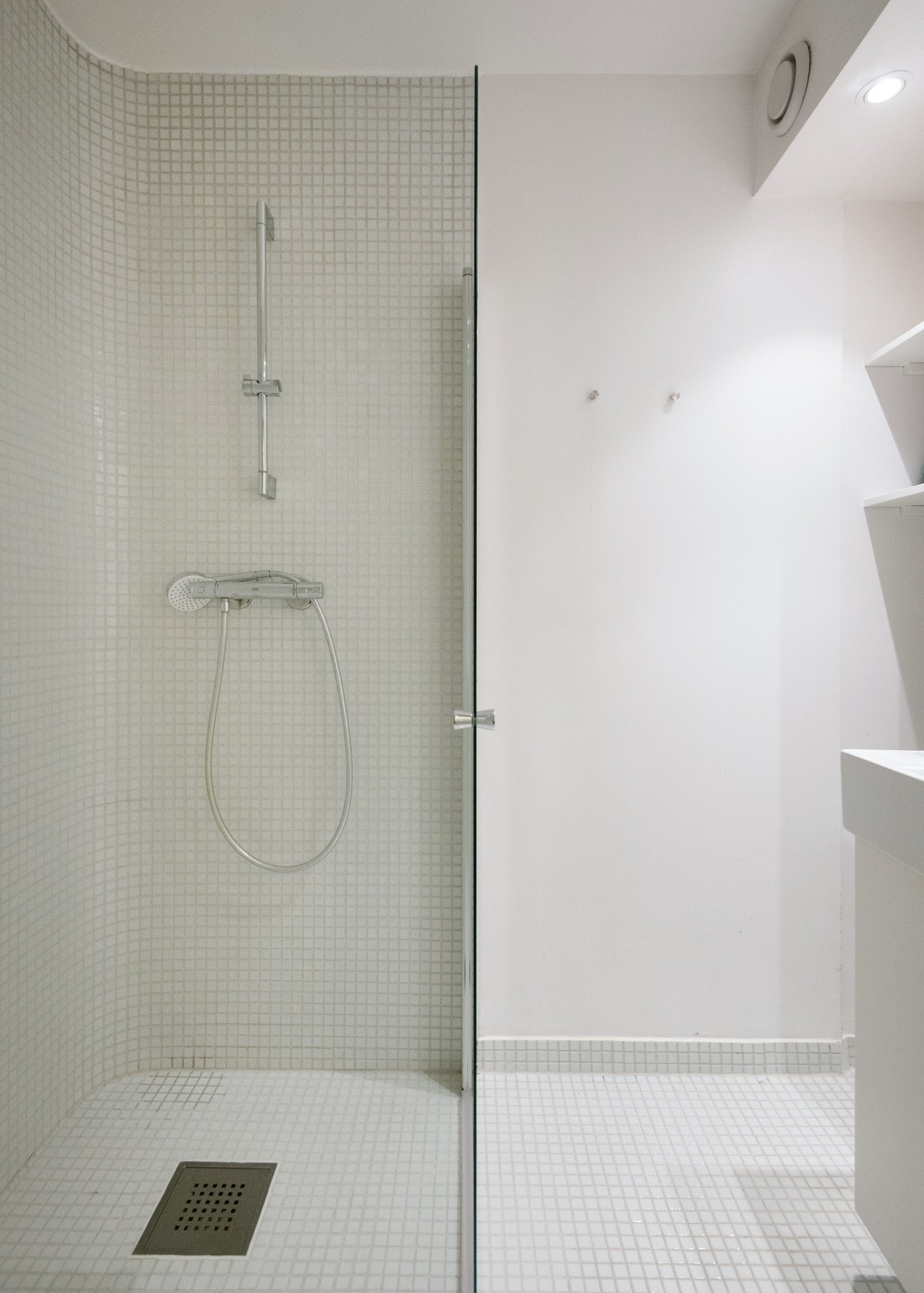 Badet er utstyrt med toalett, dusjhjørne med mosaikkfliser på gulv, samt servantinnredning. Galleribilde