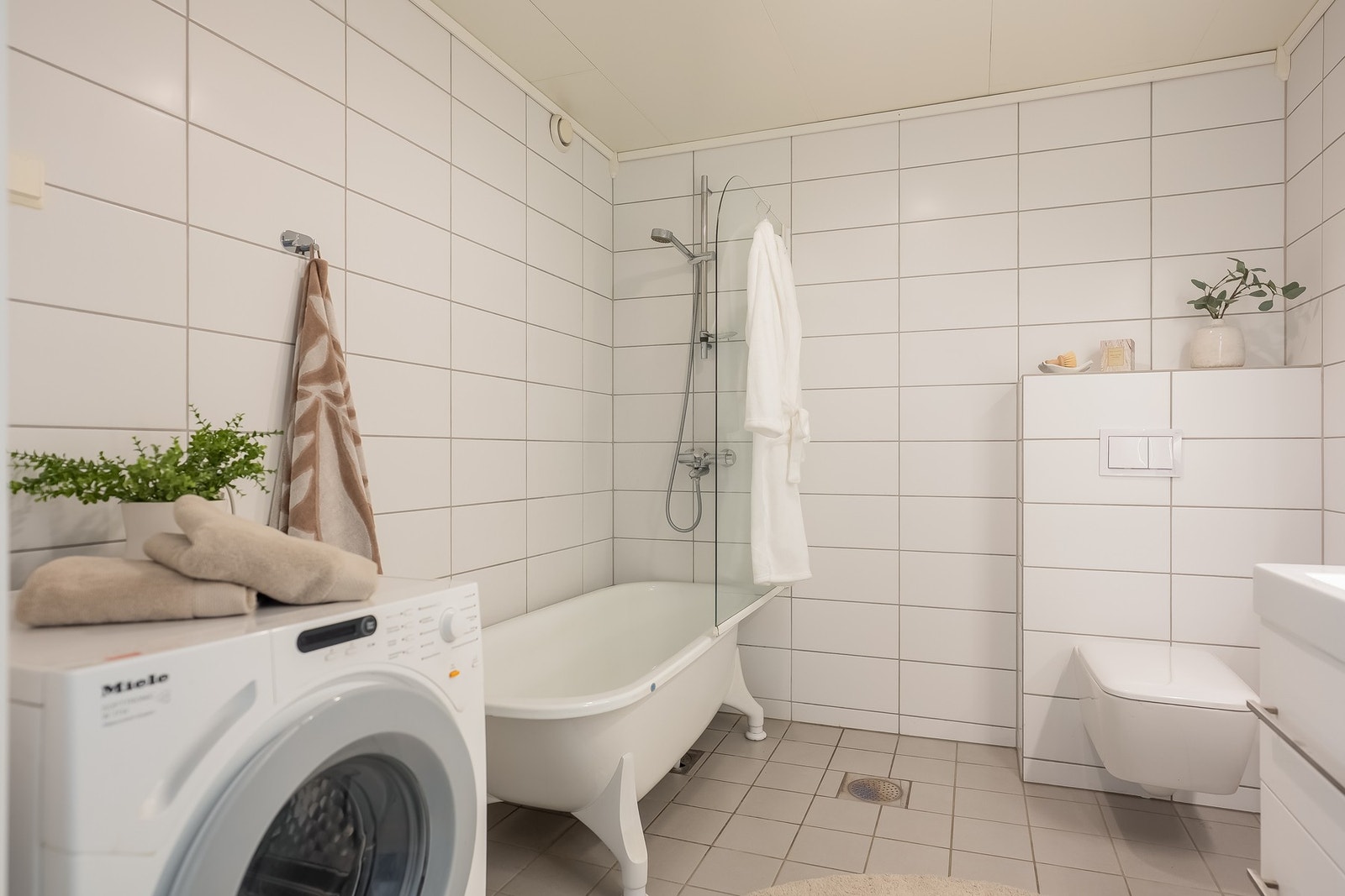God størrelse på 6 kvm med vegghengt wc, badekar med dusj, innredning og opplegg for vaskemaskin. Galleribilde