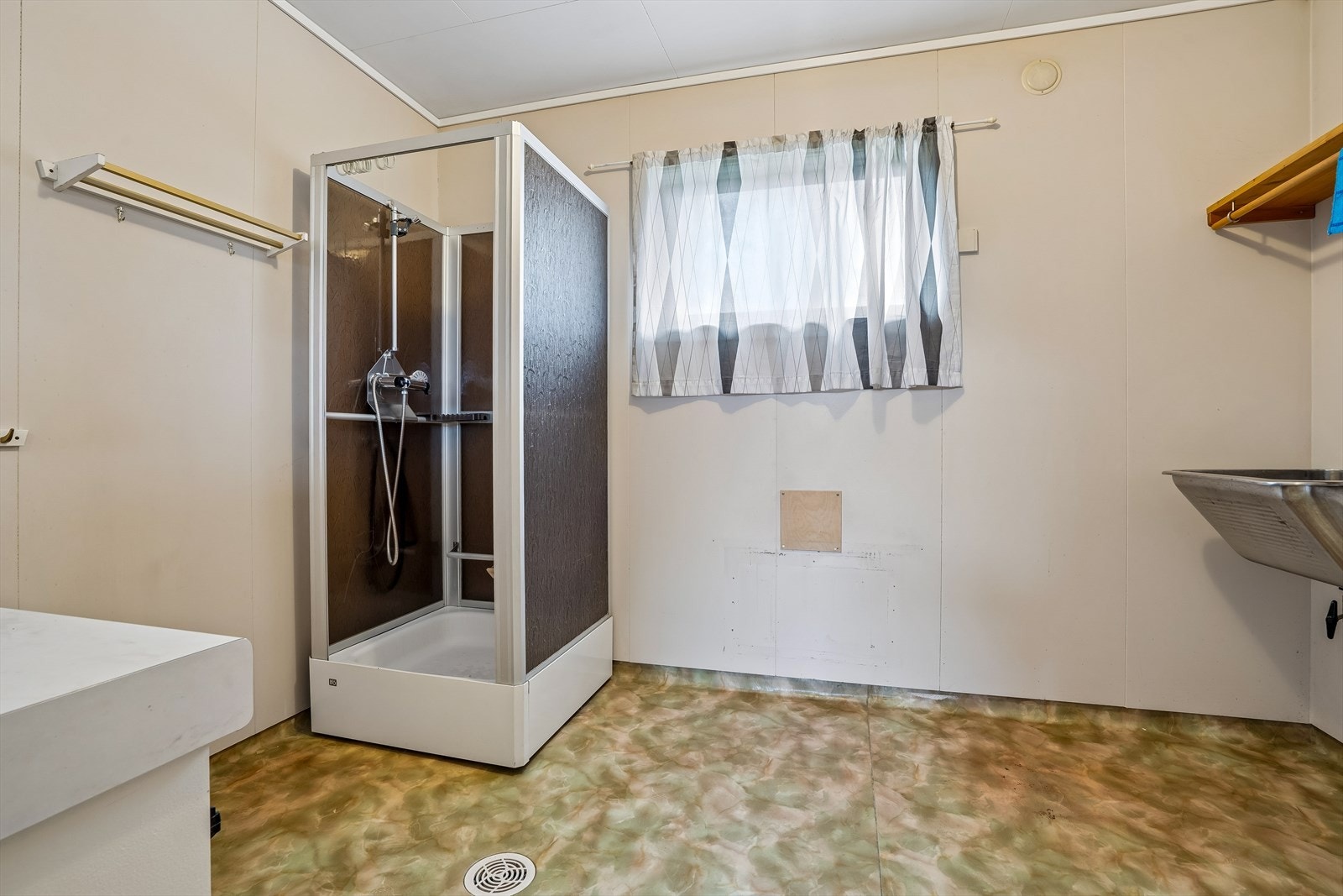 Stort vaskerom innredet med dusjkabinett, servant og opplegg for vaskemaskin. Galleribilde
