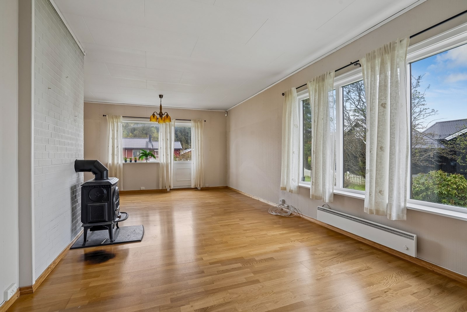 Romslig stue med godt med naturlig lysinnslipp fra de store vindusflatene. Galleribilde