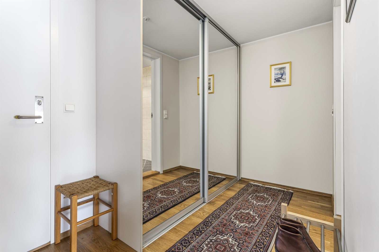 Leiligheten har et lyst inngangsparti og et stort tilhørende garderobeskap. Galleribilde