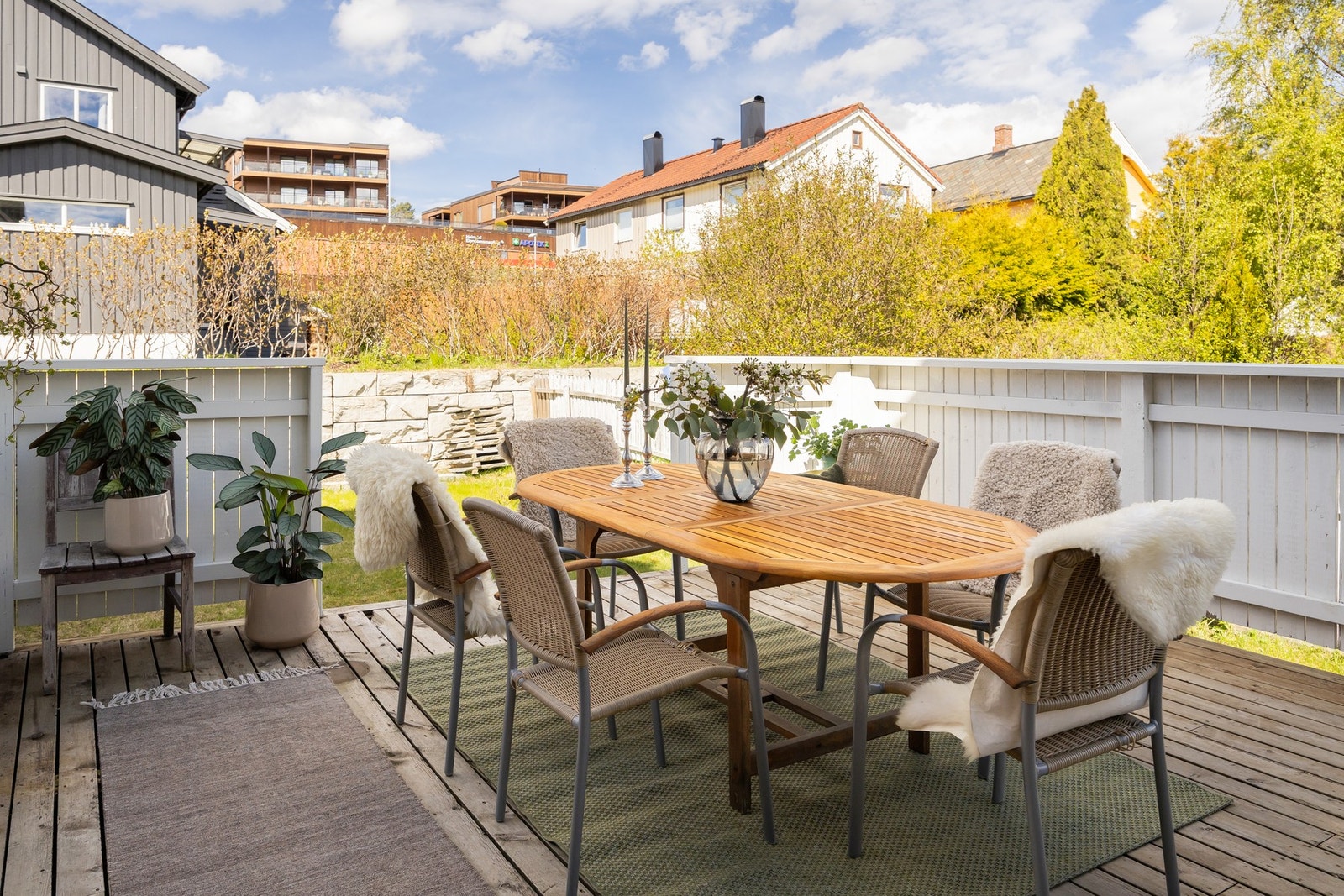 Skjermet terrasse på baksiden av huset med ettermiddags- og kveldssol. Her har man tilgang fra stua og hagen. Galleribilde