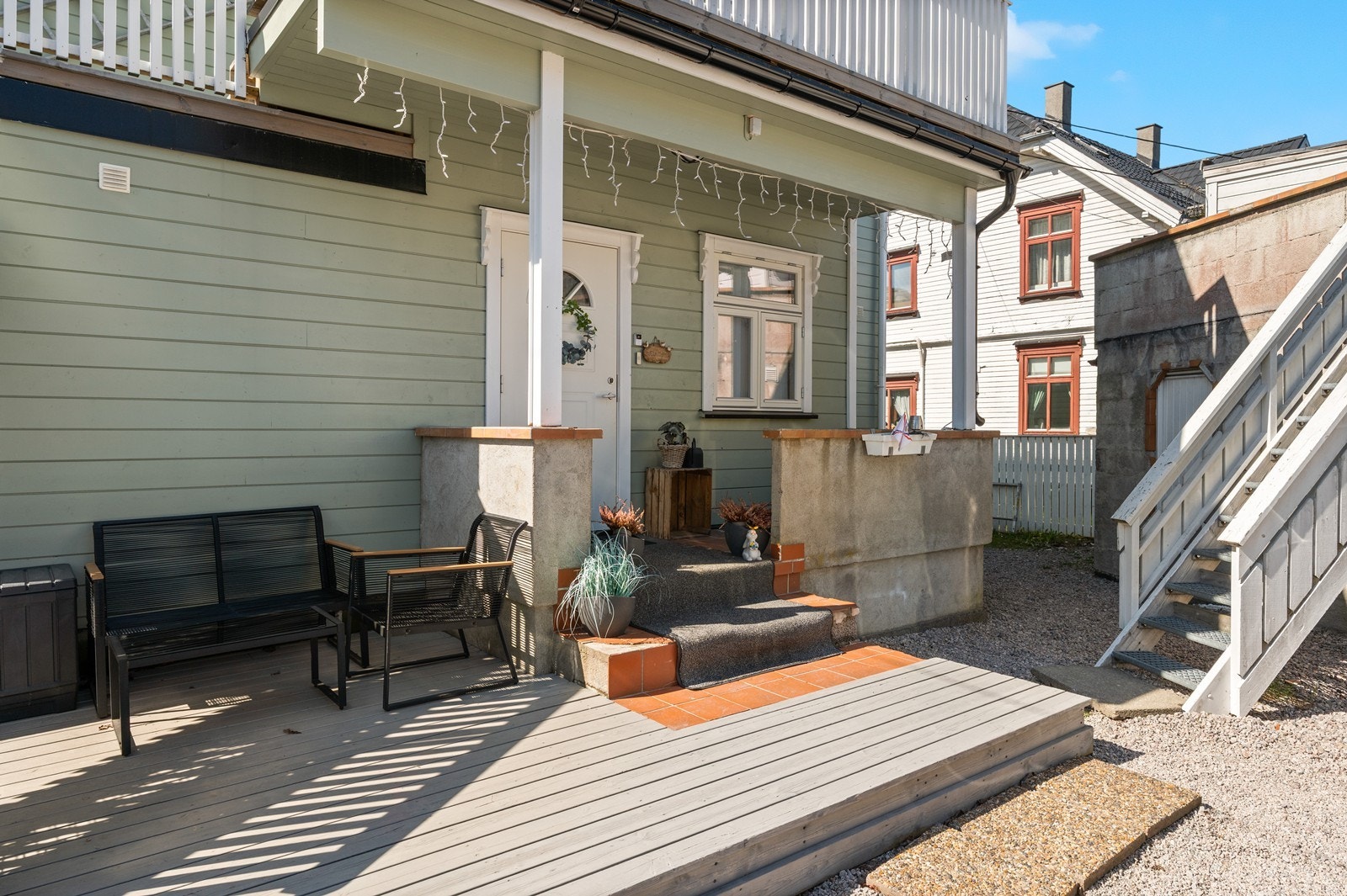 Inngangspartiet til første etasje har en treveranda og en flislagt betongtrapp. Galleribilde