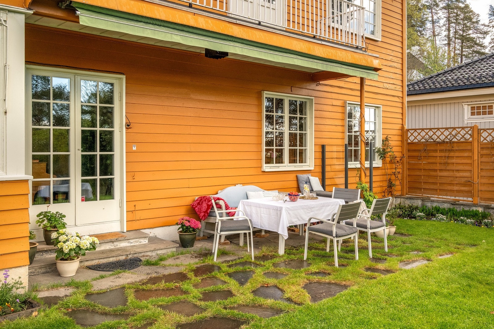Fra stuen er det en delvis overbygget markterrasse med elektrisk markise som skjermer for både sol og regn. Galleribilde