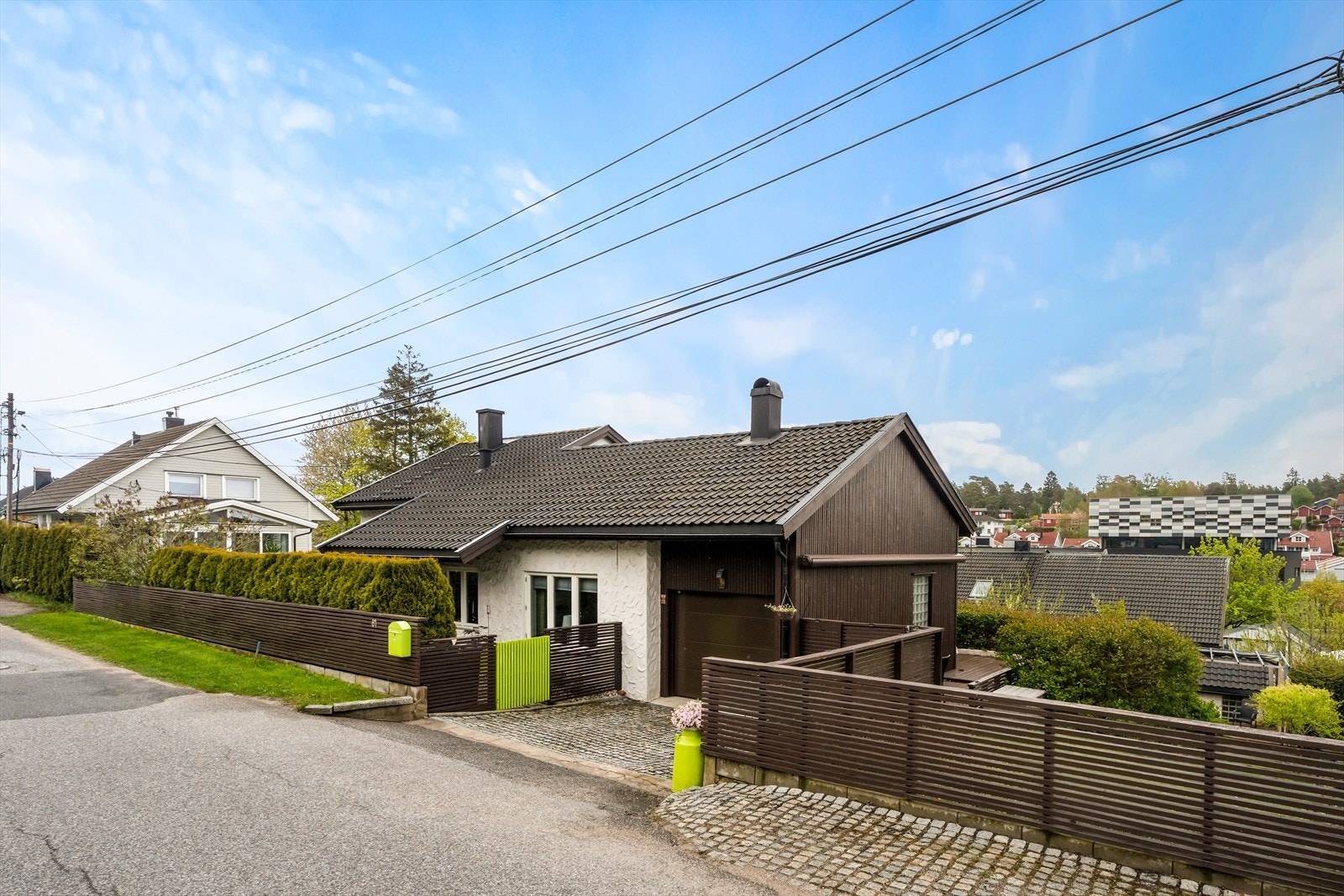 Enebolig fra 1957 med integrert garasje og pent opparbeidet, steinbelagt gårdsplass. Galleribilde