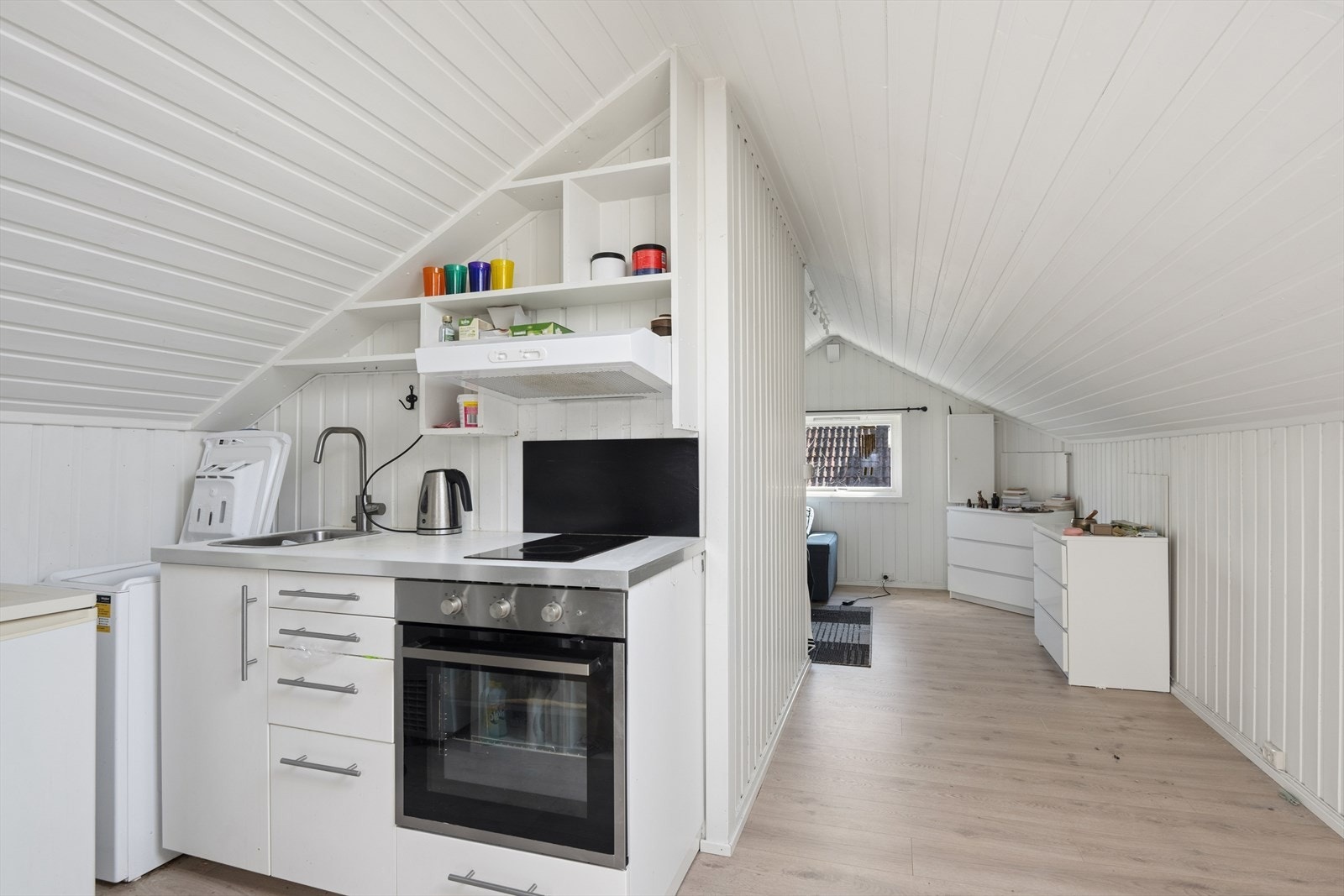 Kjøkkenløsning på loftet med plassbygde hyller som utnytter plassen under skråtaket (ikke godkjent). Om man åpner mellom hoveddel og loft, så kan rommet benyttes som hybel. Galleribilde