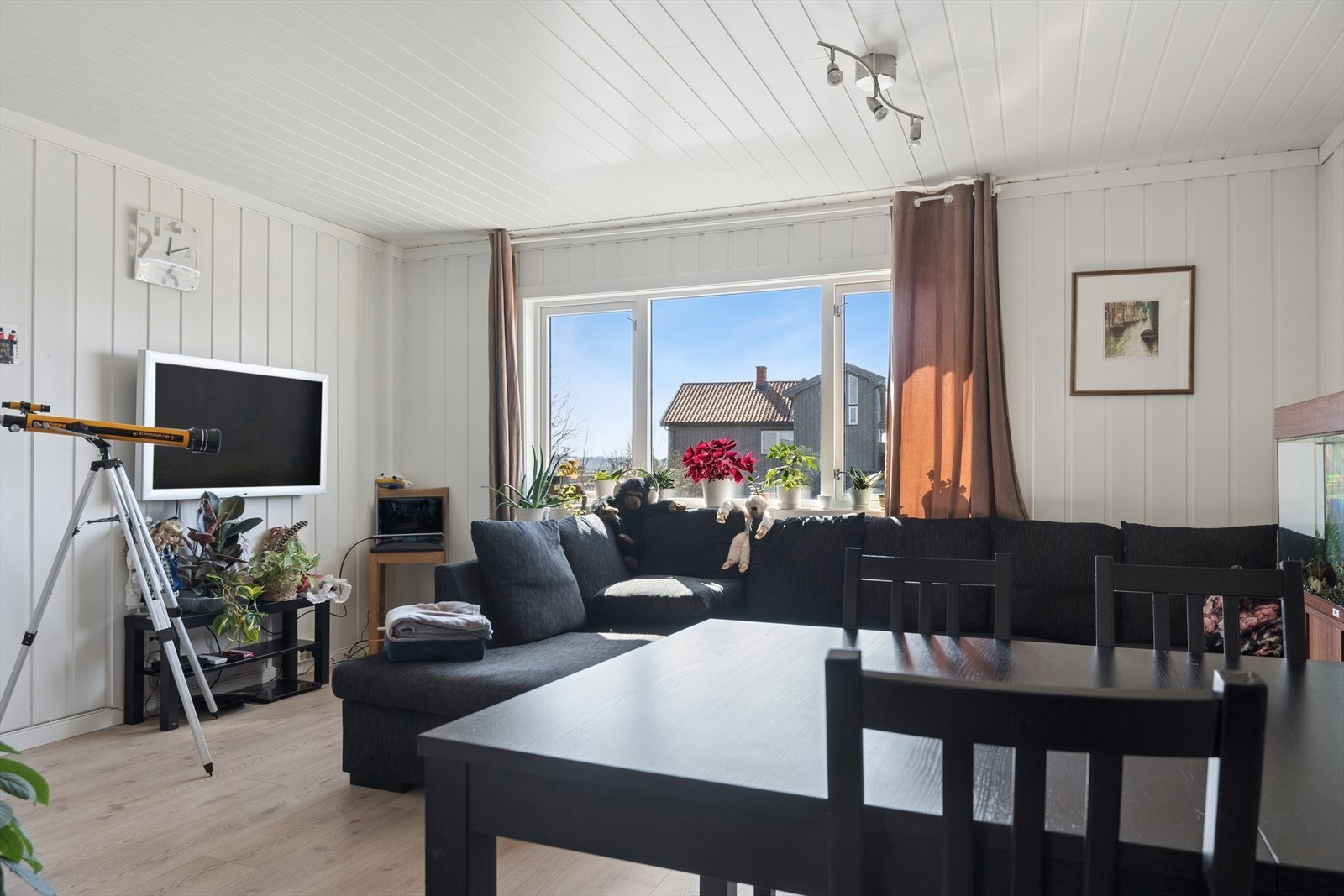 Stuen i første etasje har panelplater på veggene og plass til både sofagruppe og spisebord. Galleribilde