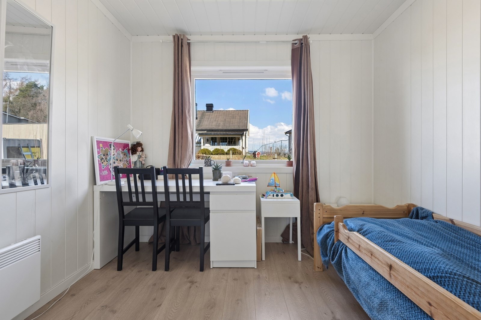 Soverom med laminatgulv og plass til skrivepult ved vinduet. Galleribilde
