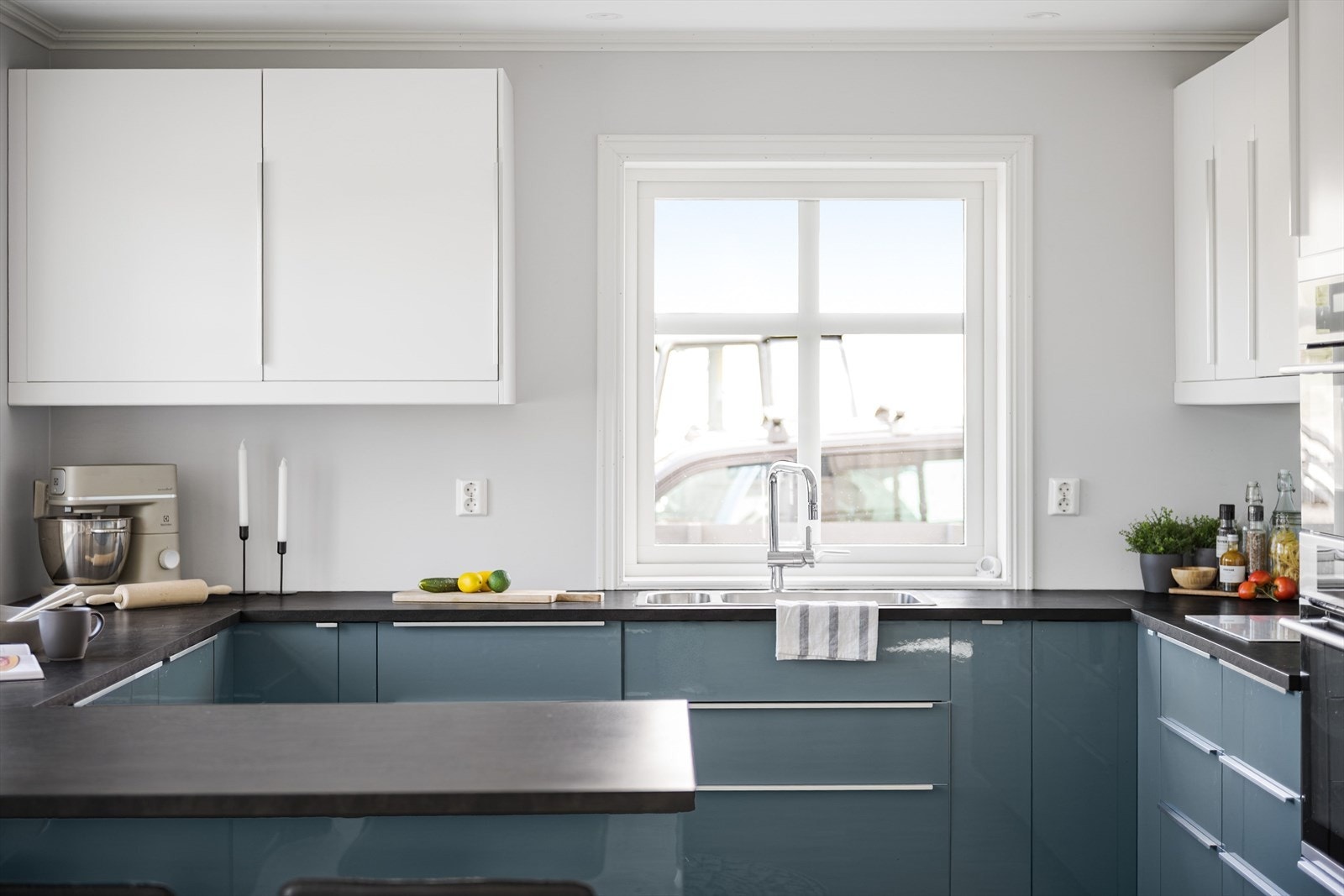 Stilrent og moderne Ikea-kjøkken fra 2018. Innredningen har glatte fronter og laminert benkeplate med nedfelt oppvaskkum. Praktisk med glassplate i benkeryggen ved platetoppen. Galleribilde