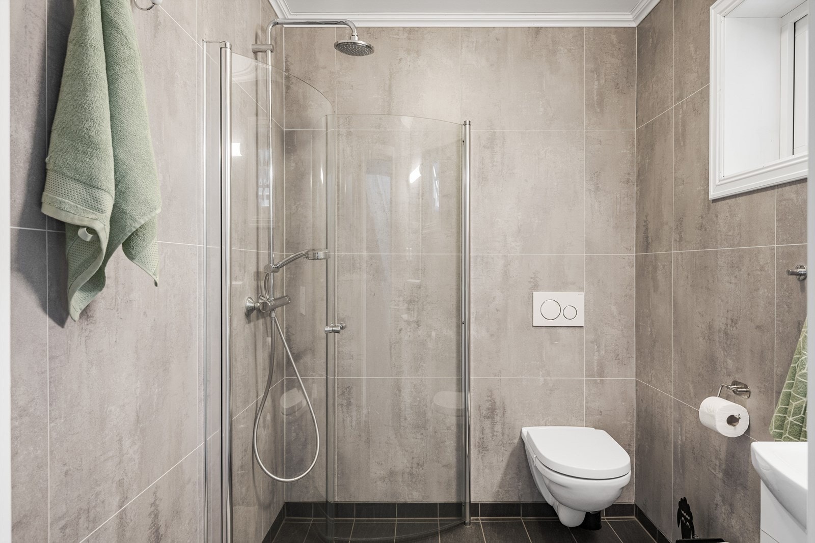Moderne baderom i 1. etasje fra byggeåret 2018. Baderommet har flislagt gulv med vannbåren gulvvarme, våtromsplater på veggene, downlights i himlingen og avtrekk via balansert ventilasjon. Galleribilde